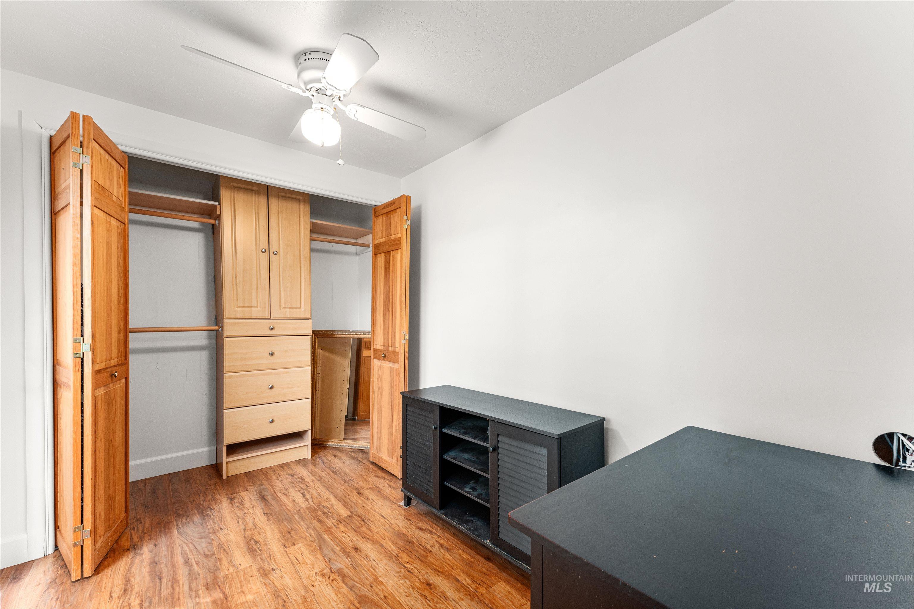 Unfurnished bedroom featuring light wood-style flooring, a ceiling fan, and a closet