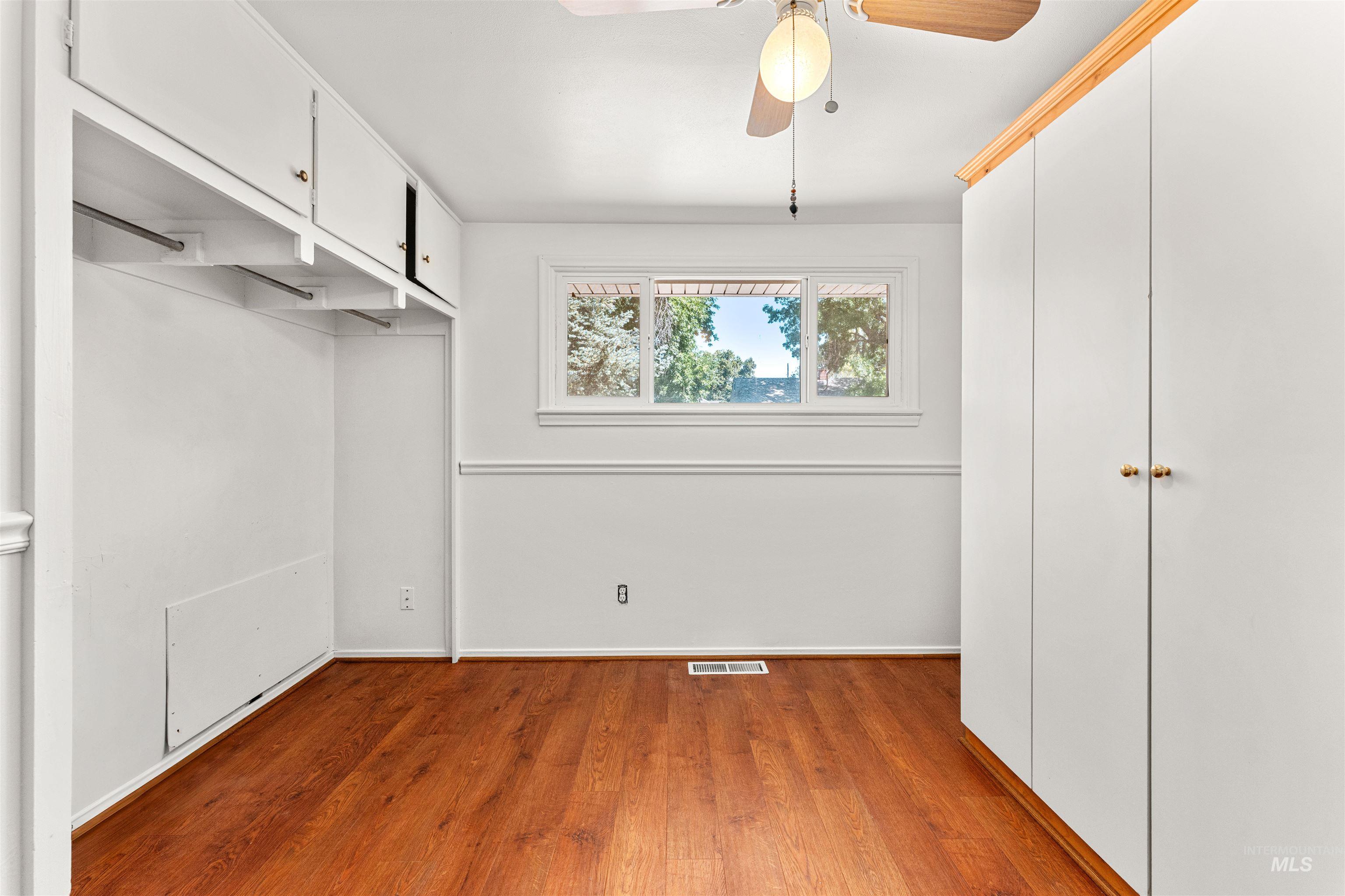 Unfurnished bedroom featuring wood finished floors, ceiling fan, and a closet