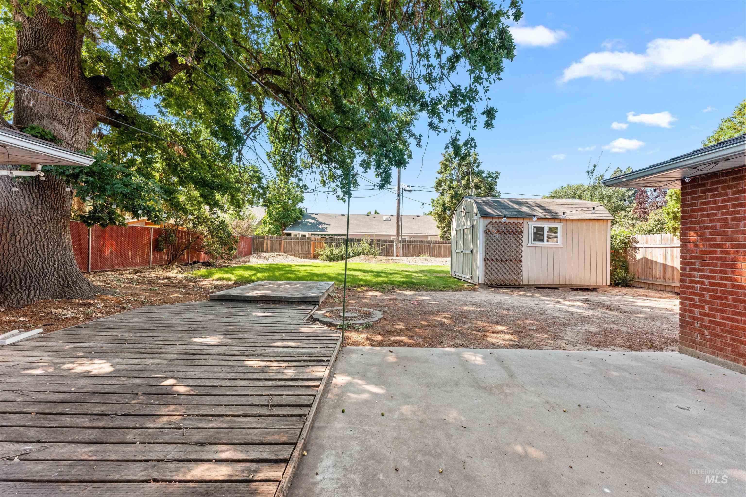 Fenced backyard featuring a patio and a storage shed