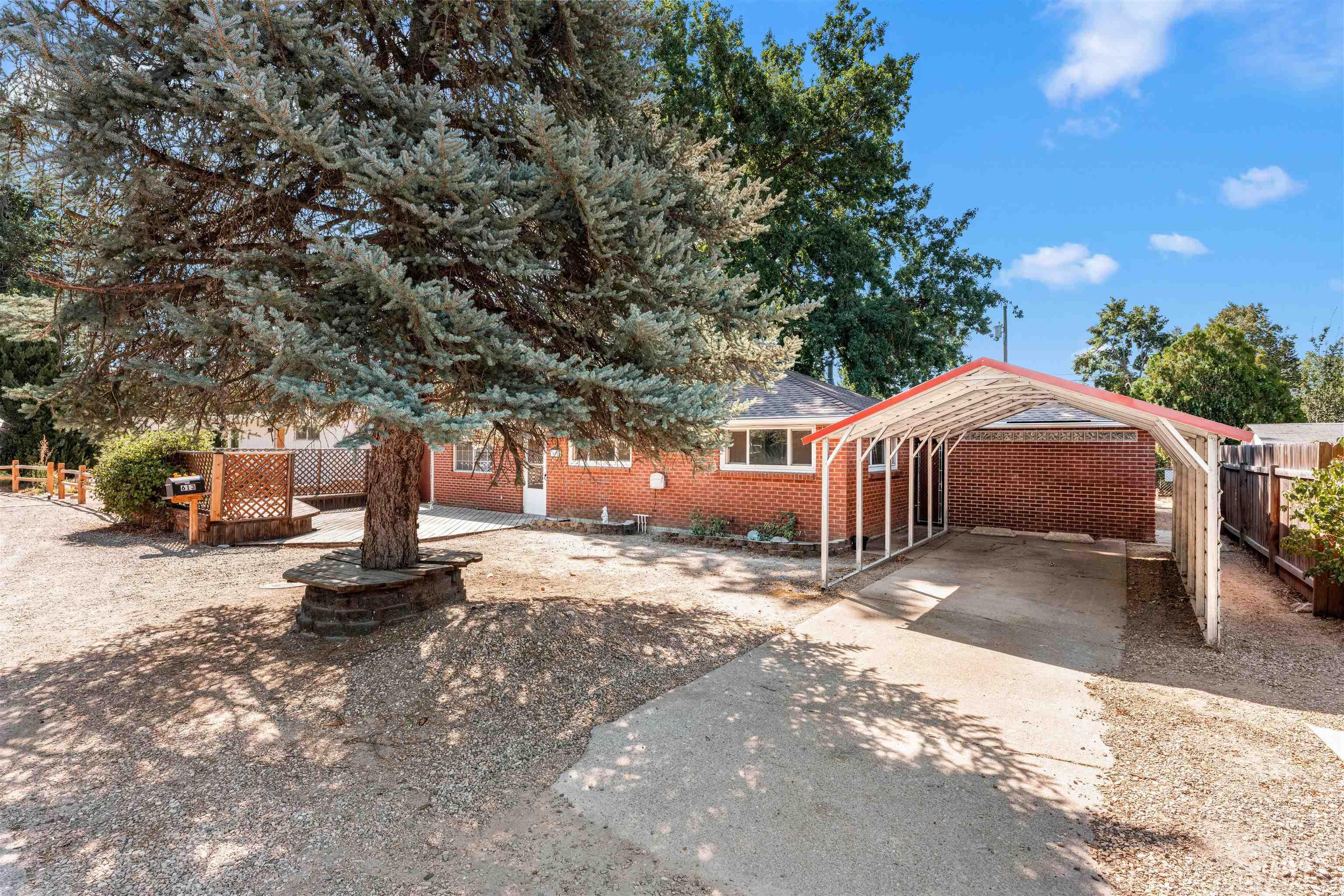View of front of home featuring a carport, driveway, and brick siding