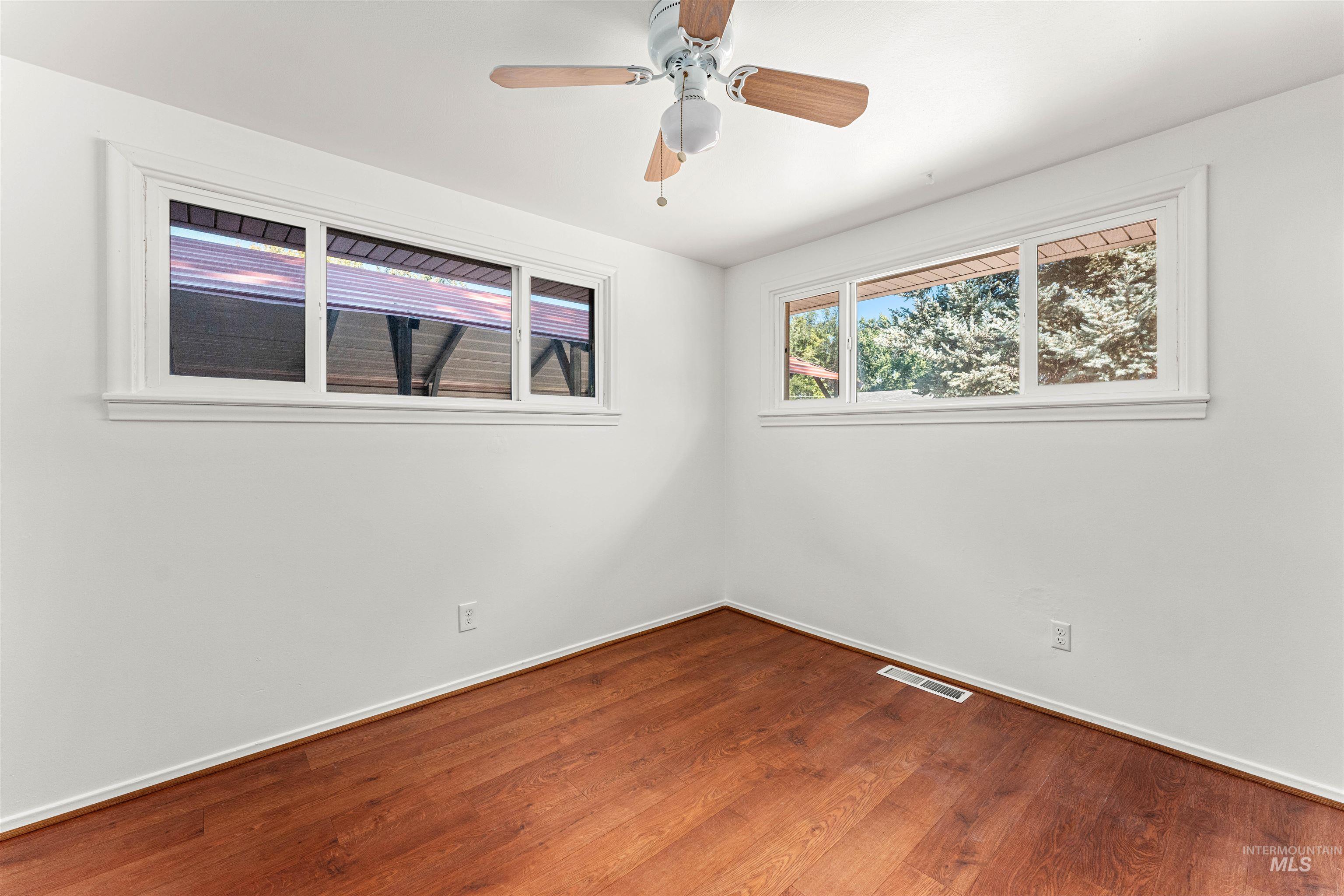 Spare room featuring wood finished floors and a ceiling fan
