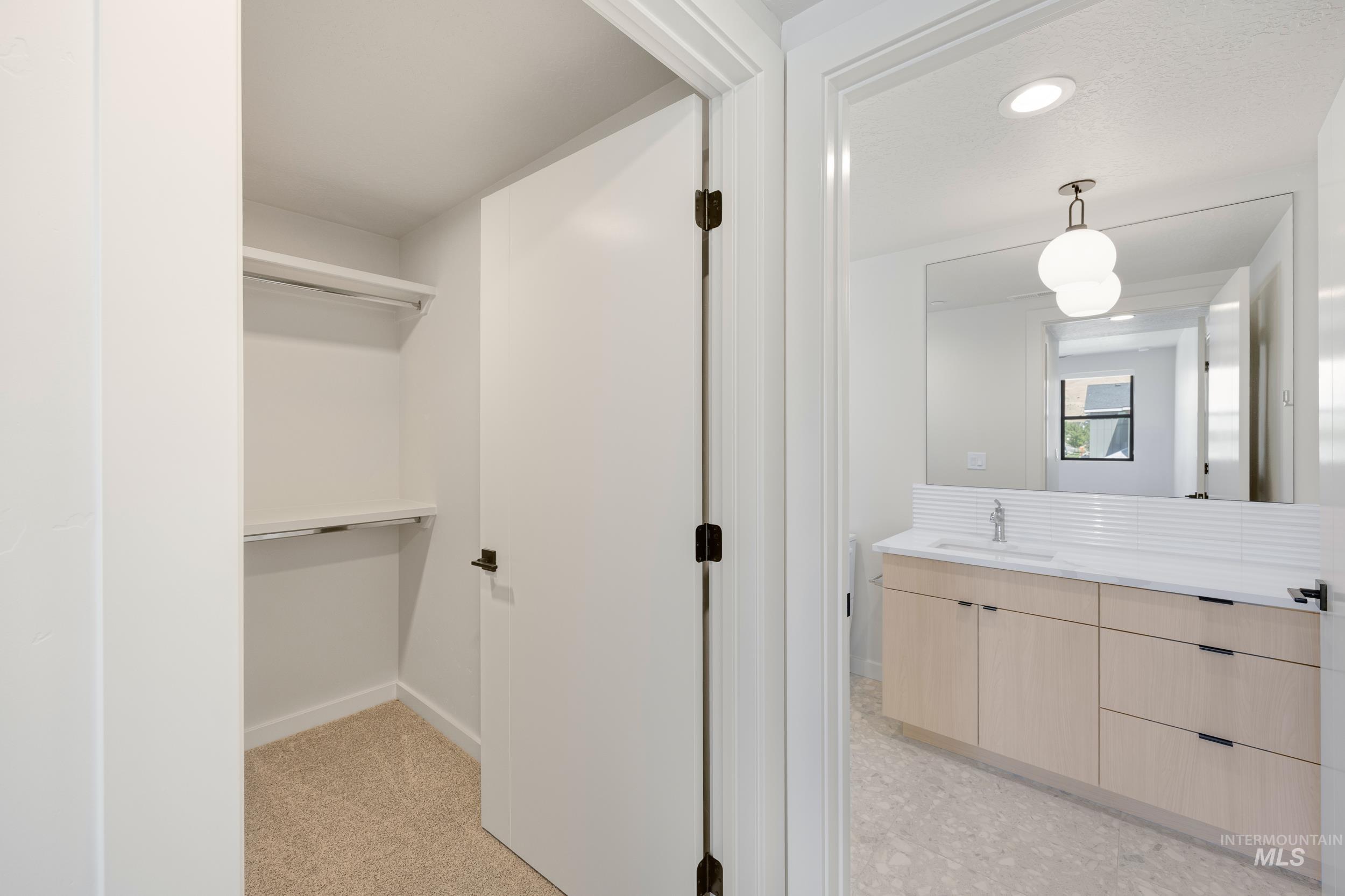 Bathroom with vanity, recessed lighting, and a walk in closet