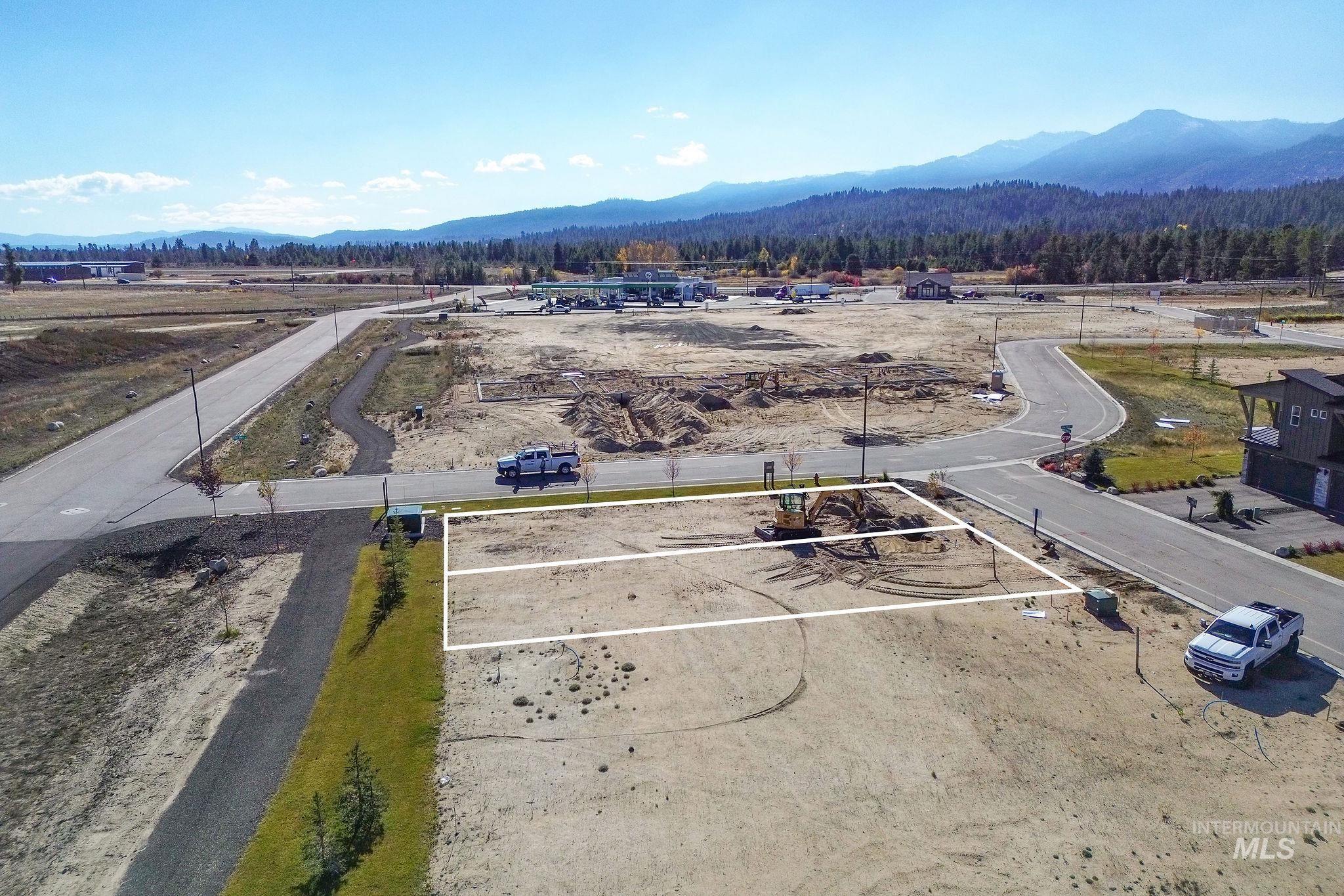 Aerial view of property and surrounding area with property boundaries highlighted and a mountain backdrop