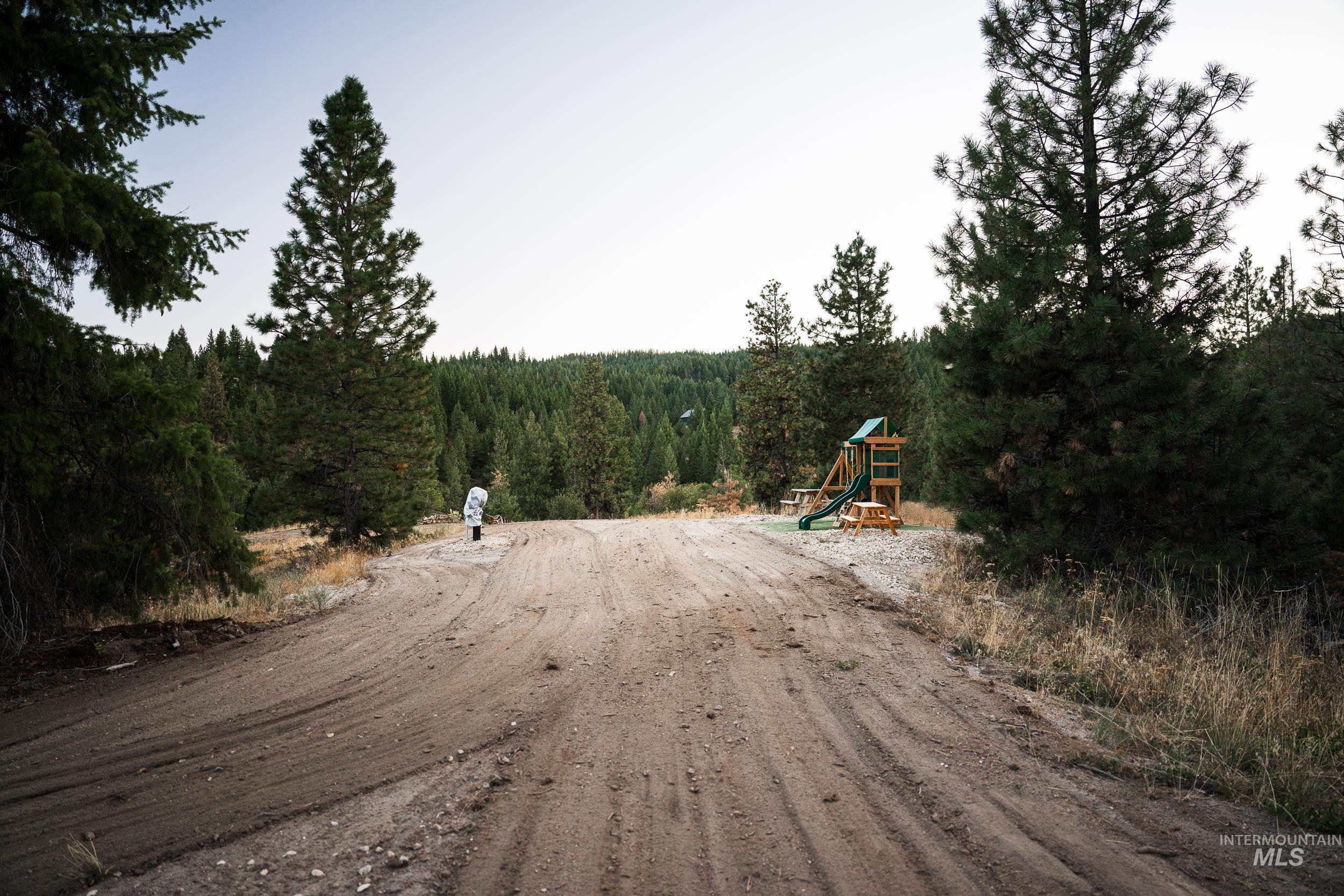 View of dirt / gravel road with a view of trees