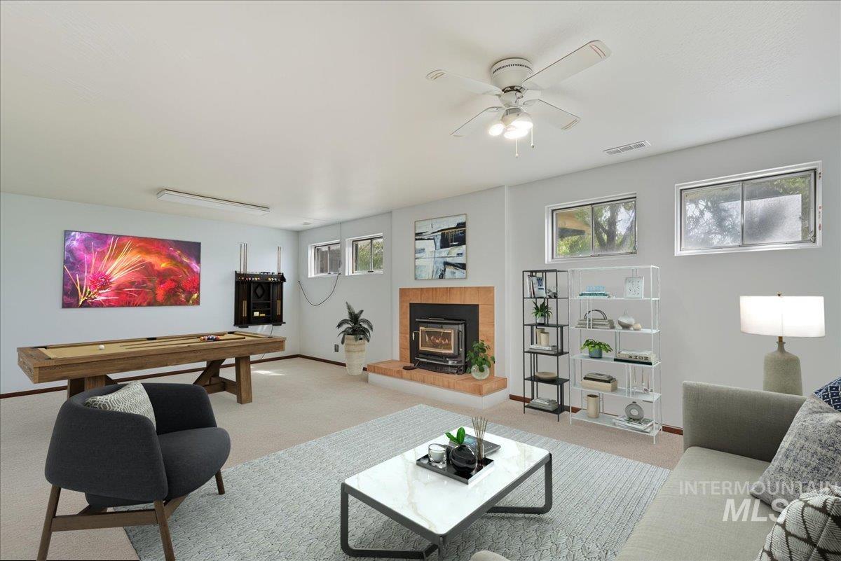 Carpeted living area with ceiling fan and room for pool table
