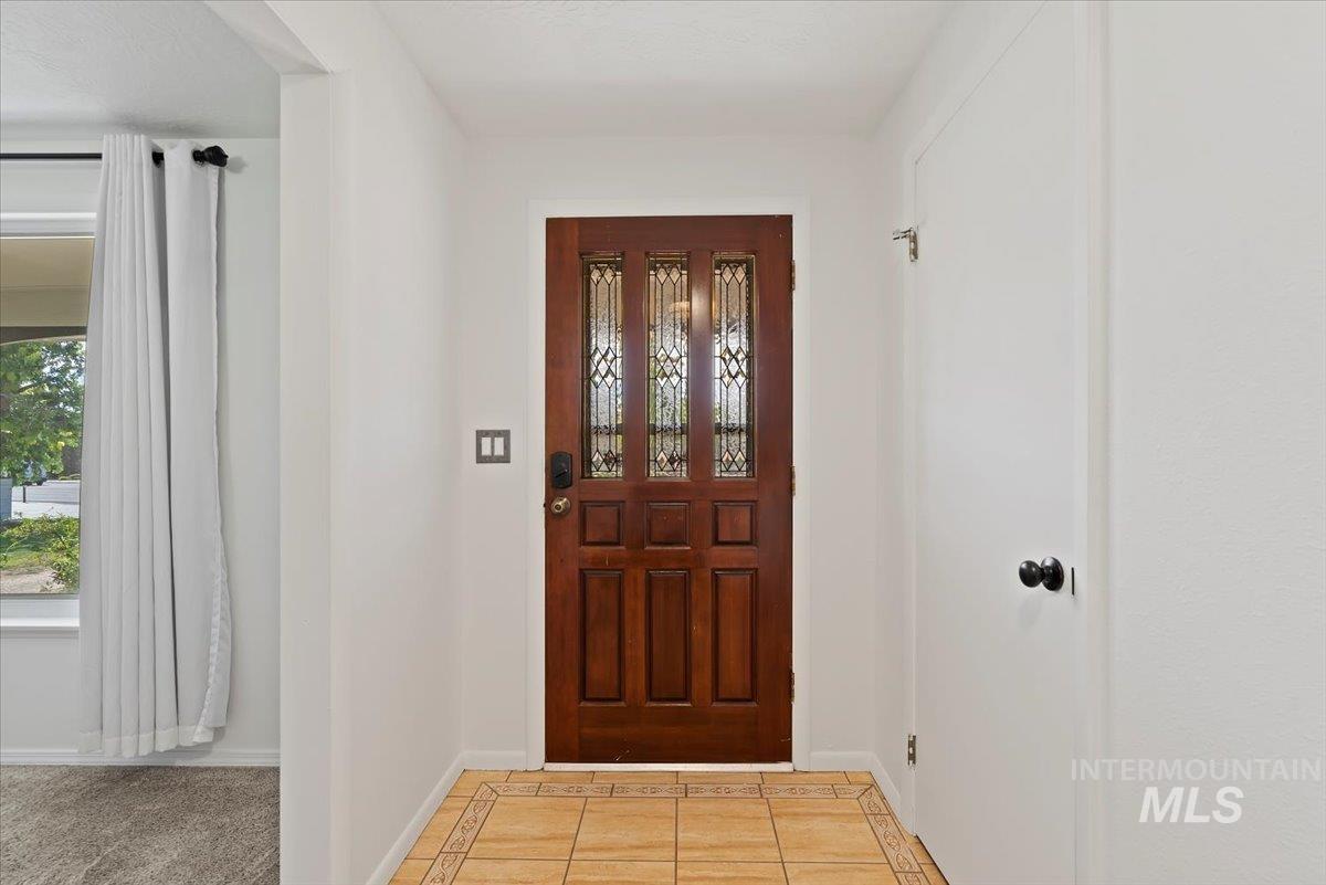 Entrance foyer with tile patterned flooring and inlaid floor details