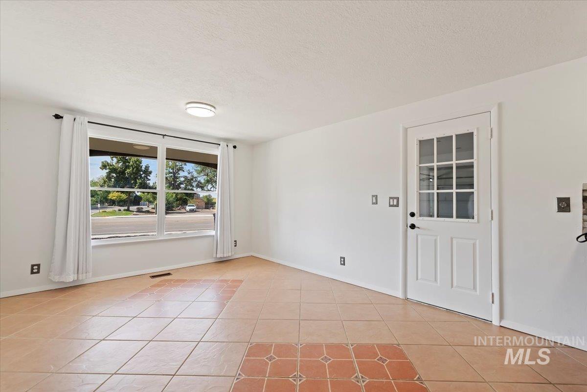 Unfurnished room with light tile patterned floors and a textured ceiling