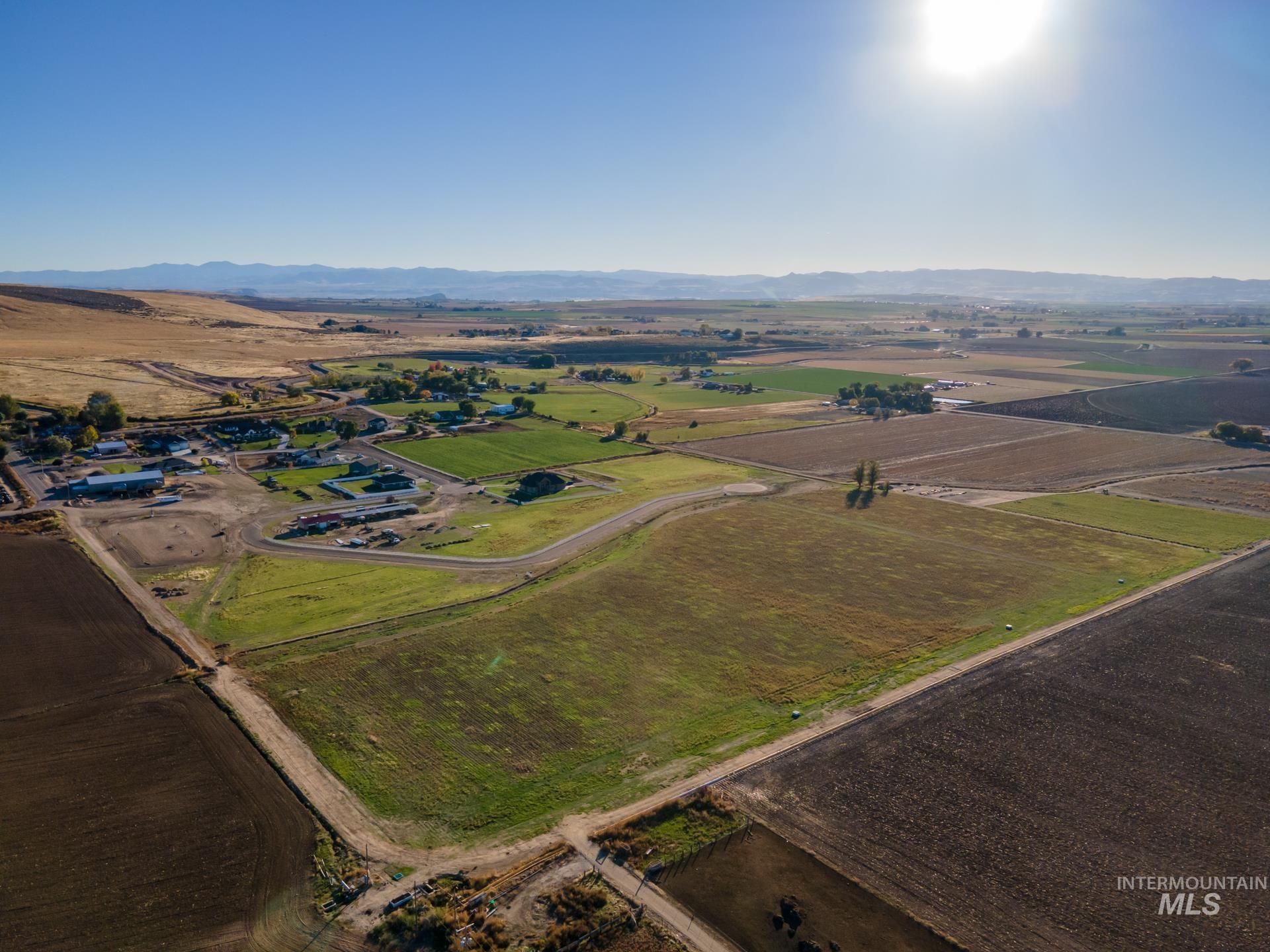 Aerial overview of property's location with rural landscape and a mountainous background