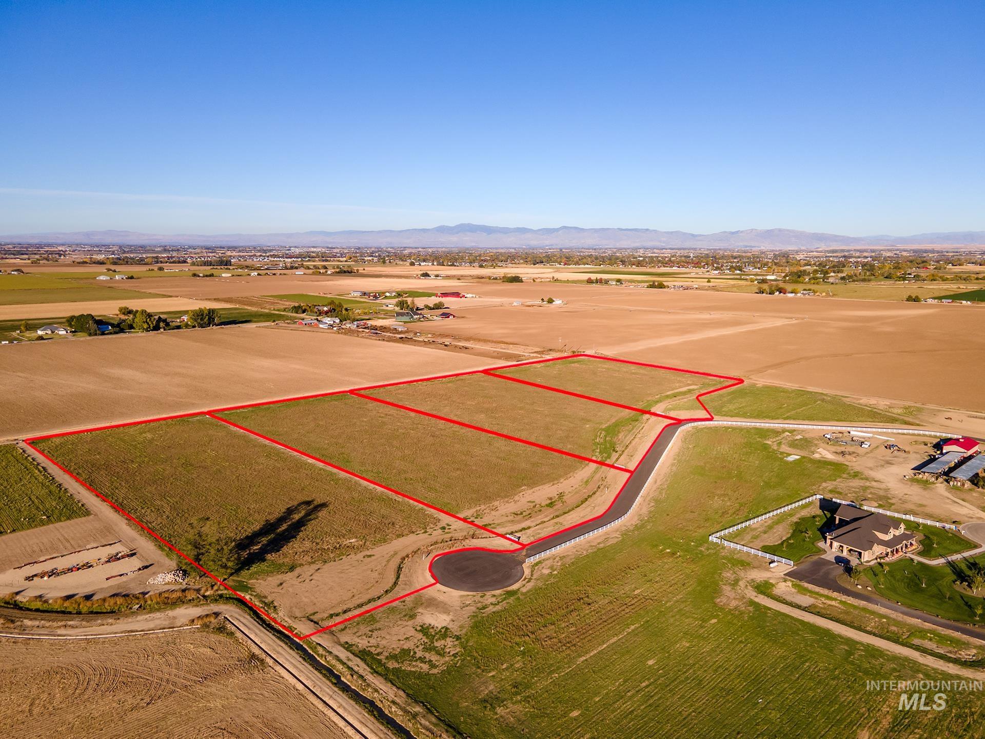 Overview of rural landscape featuring property boundaries highlighted and a mountain backdrop