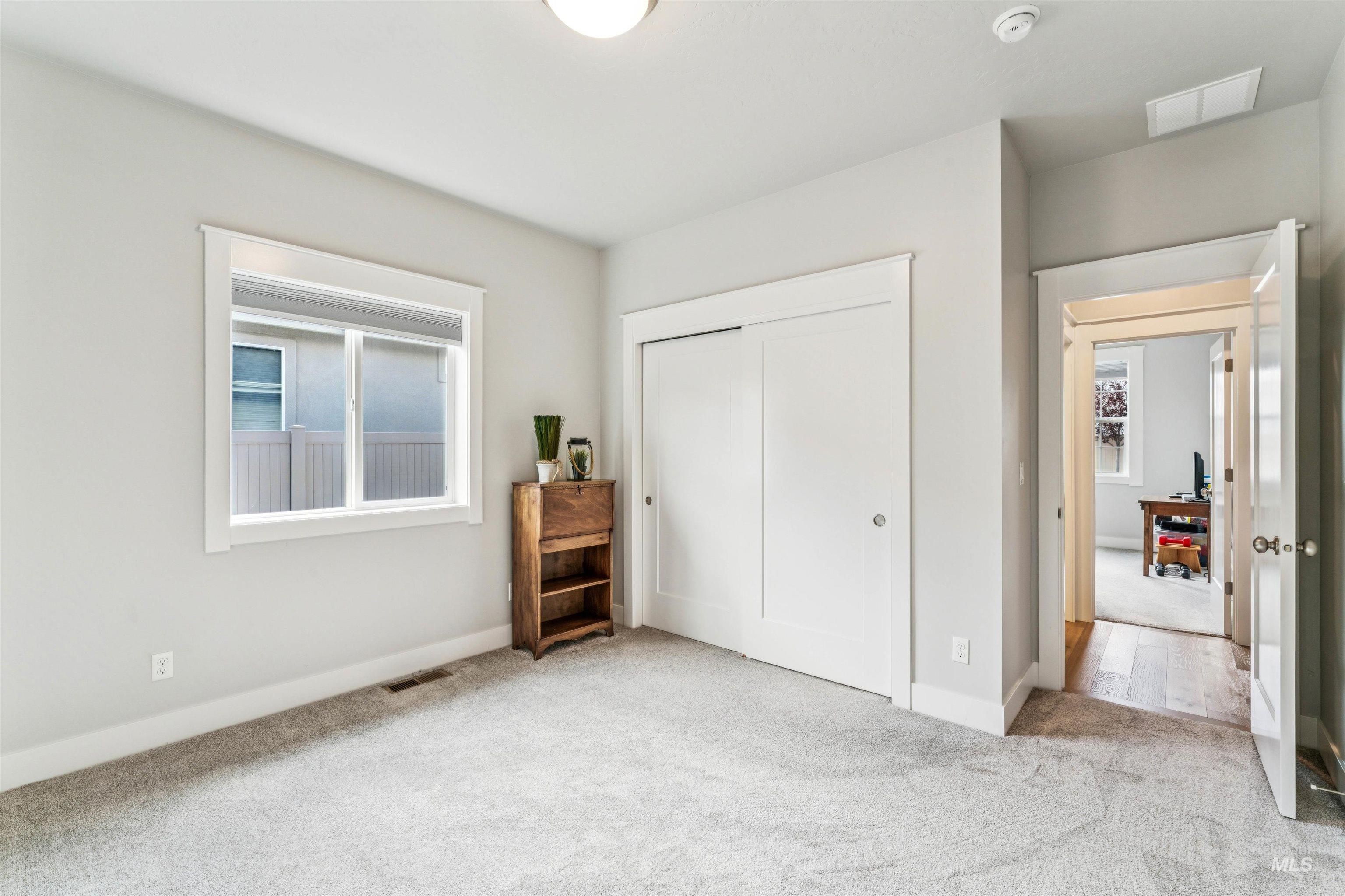 Carpeted bedroom with a closet and baseboards