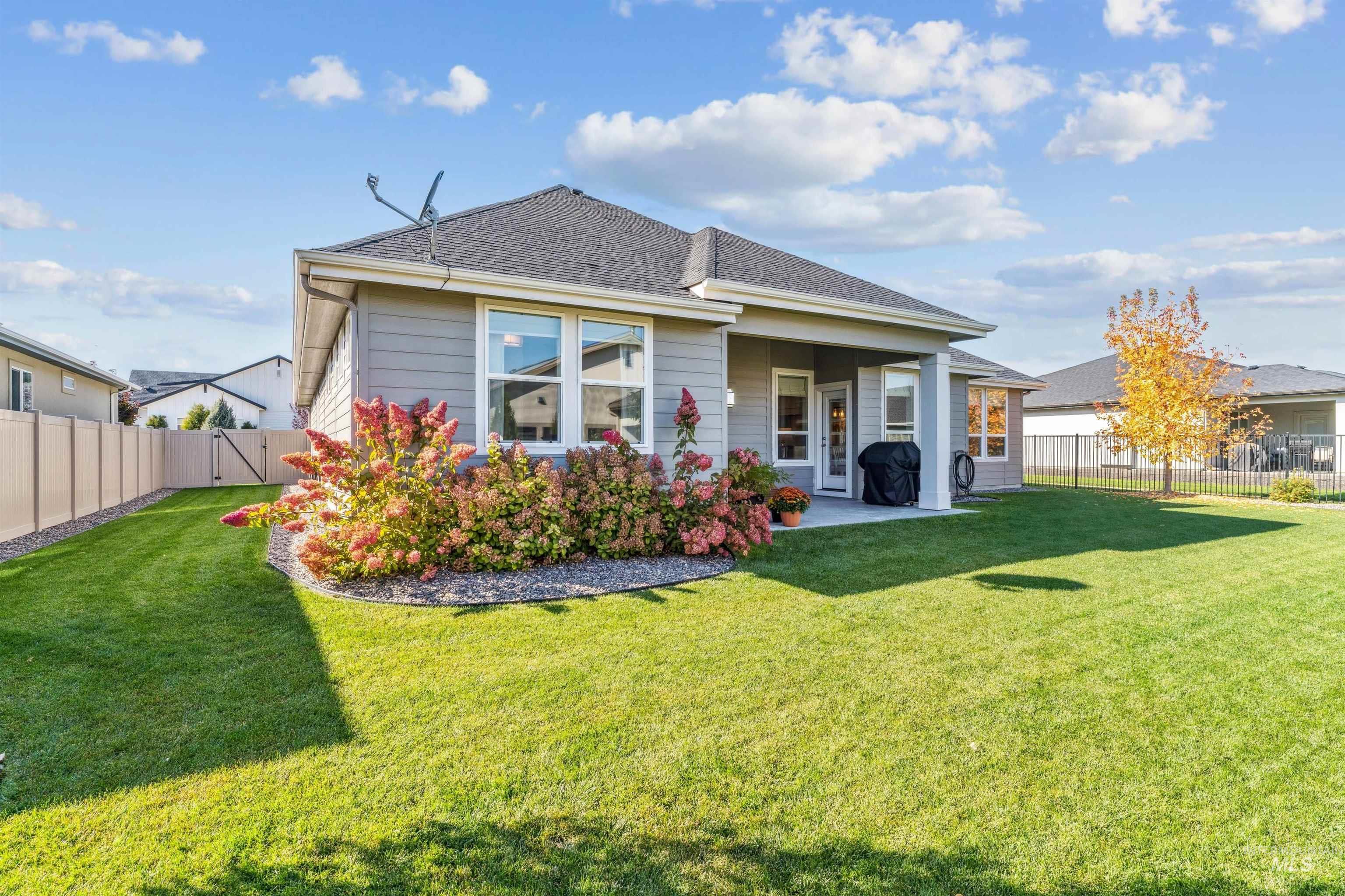 Back of property with a fenced backyard, a patio, and a shingled roof