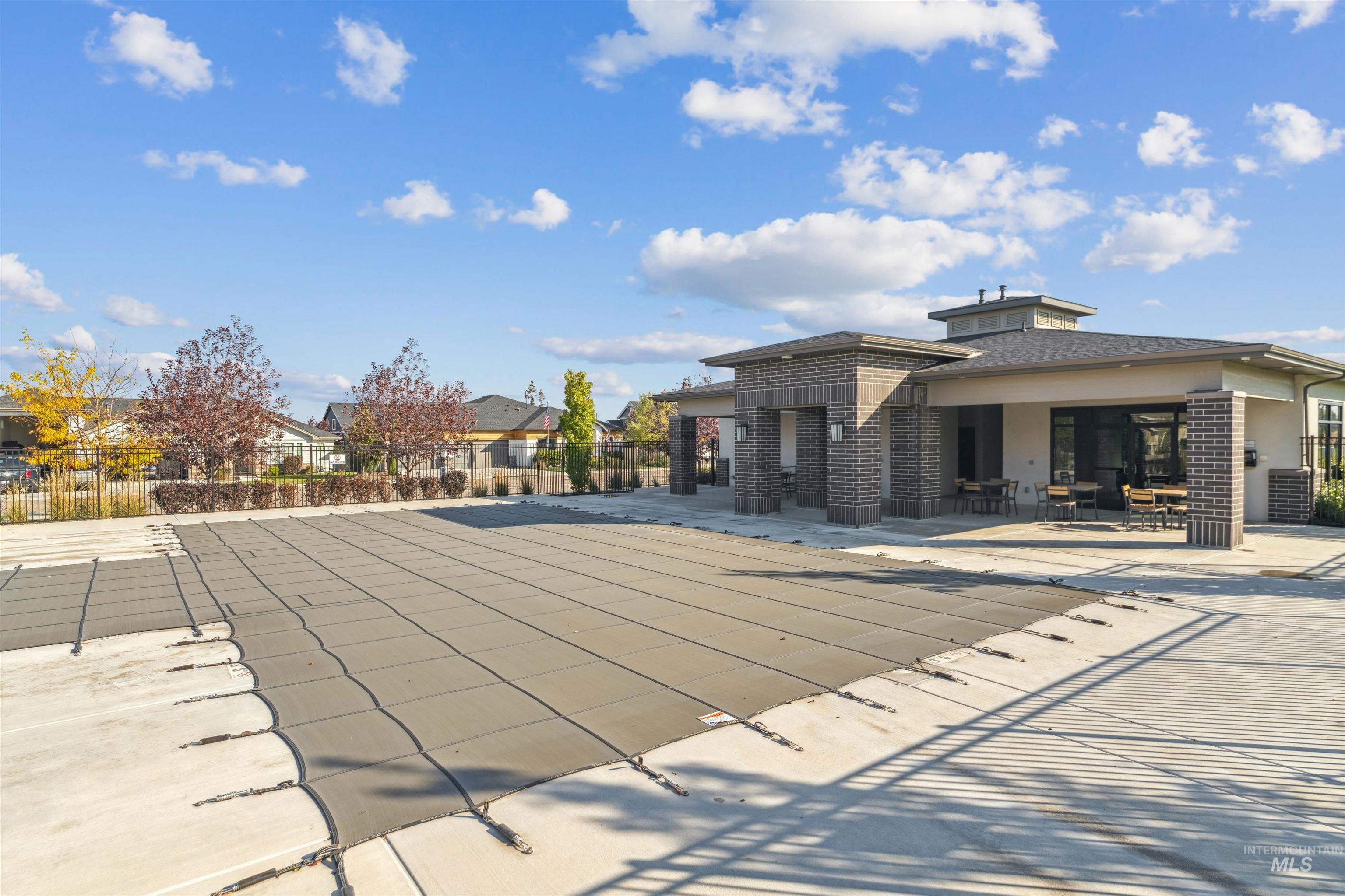 Community pool with a patio area and a residential view