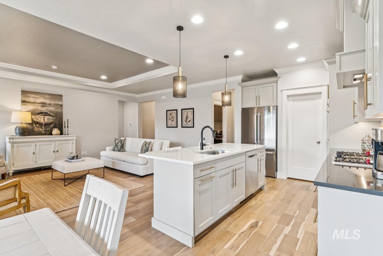 Kitchen featuring recessed lighting, pendant lighting, open floor plan, appliances with stainless steel finishes, and light wood-style floors