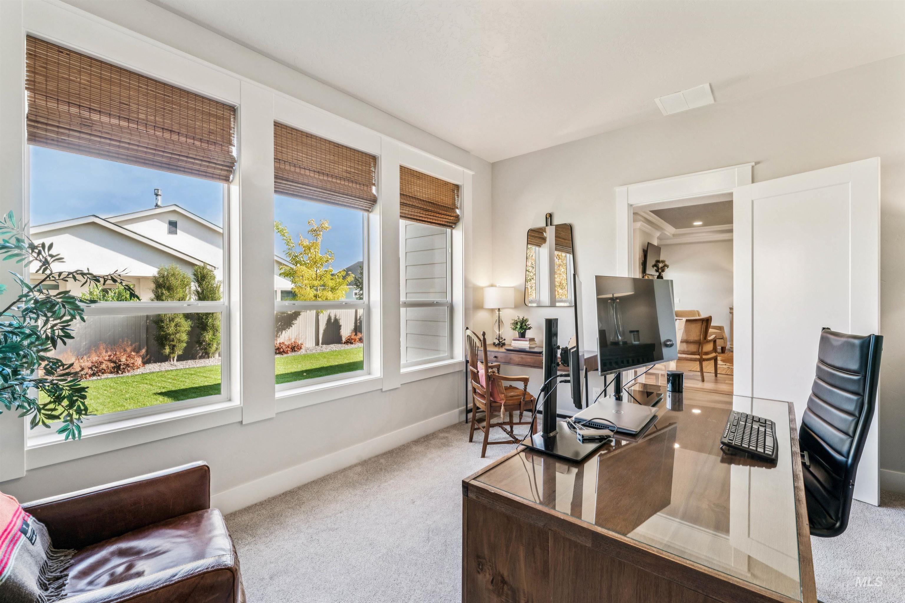 Office area featuring light colored carpet and baseboards
