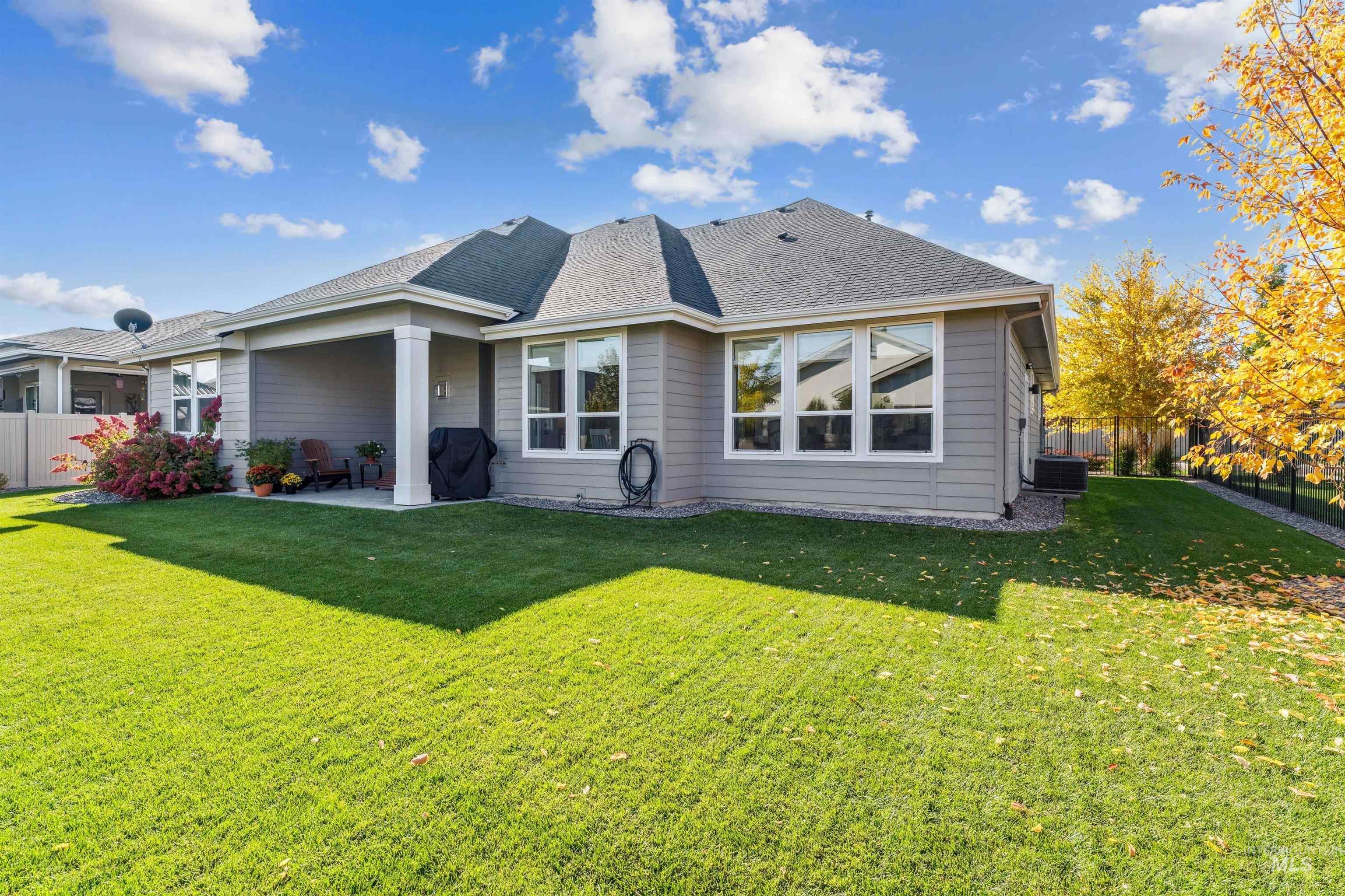 Rear view of house with a patio and a shingled roof
