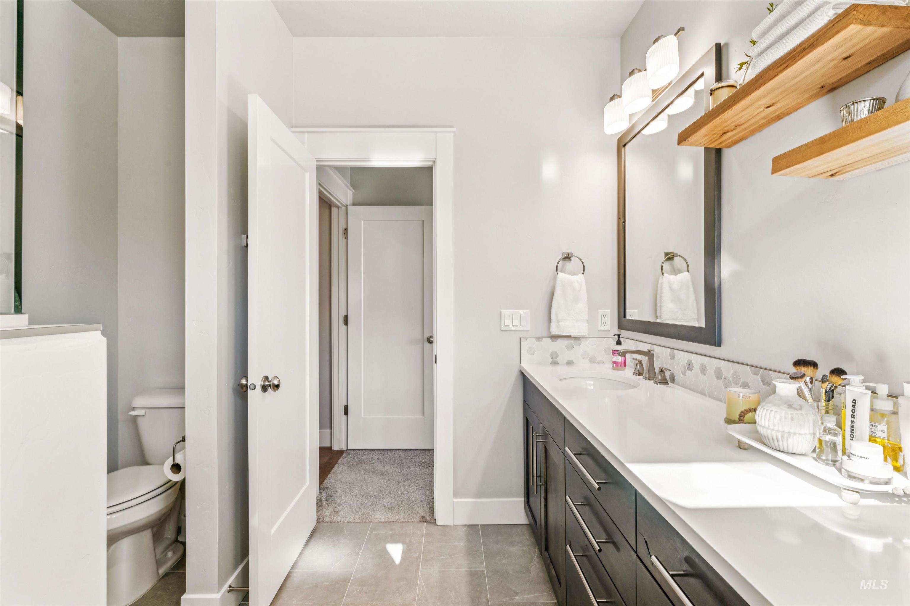 Full bathroom with double vanity and light tile patterned floors
