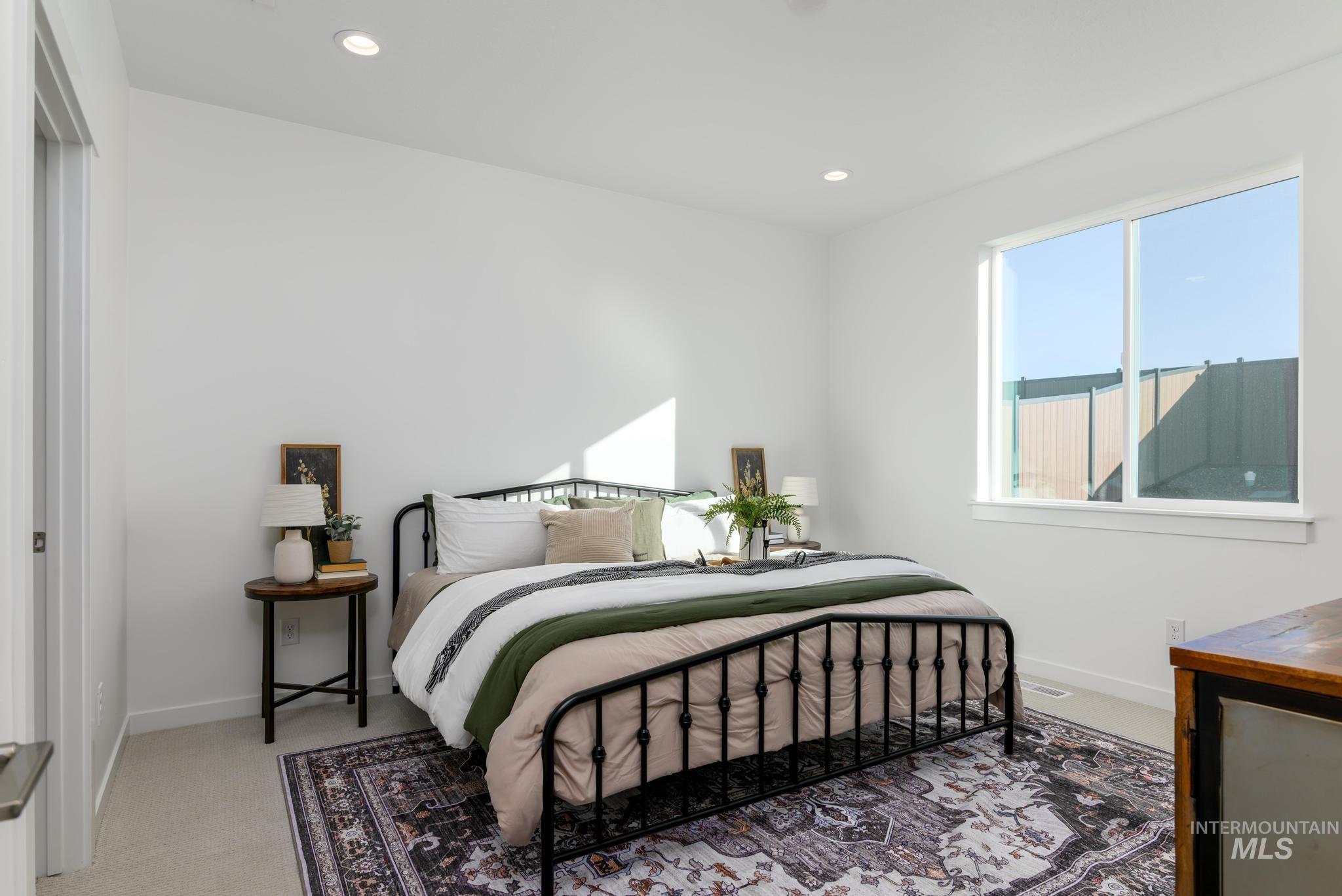 Bedroom with light carpet and recessed lighting