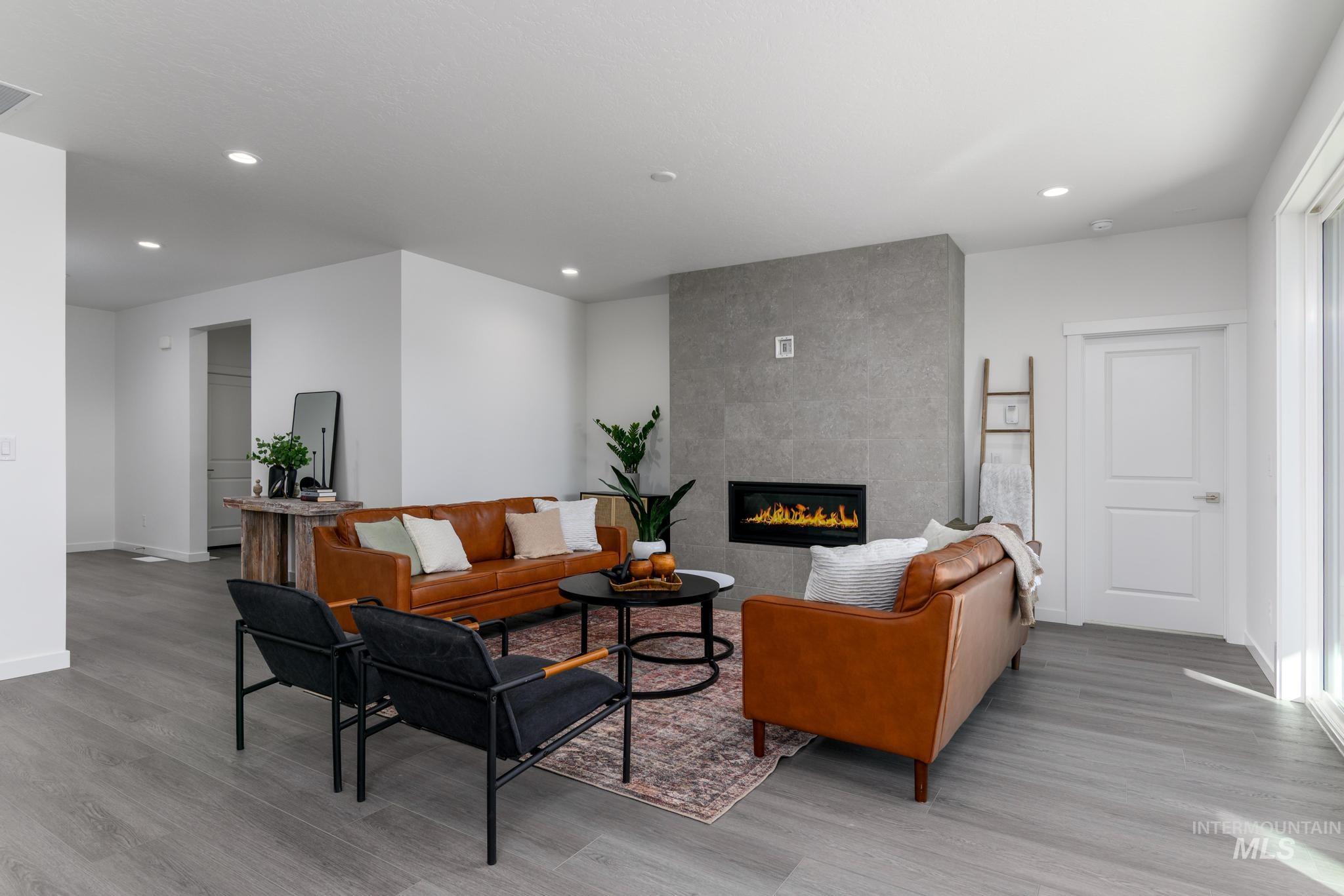 Living room featuring a fireplace, light wood-type flooring, and recessed lighting