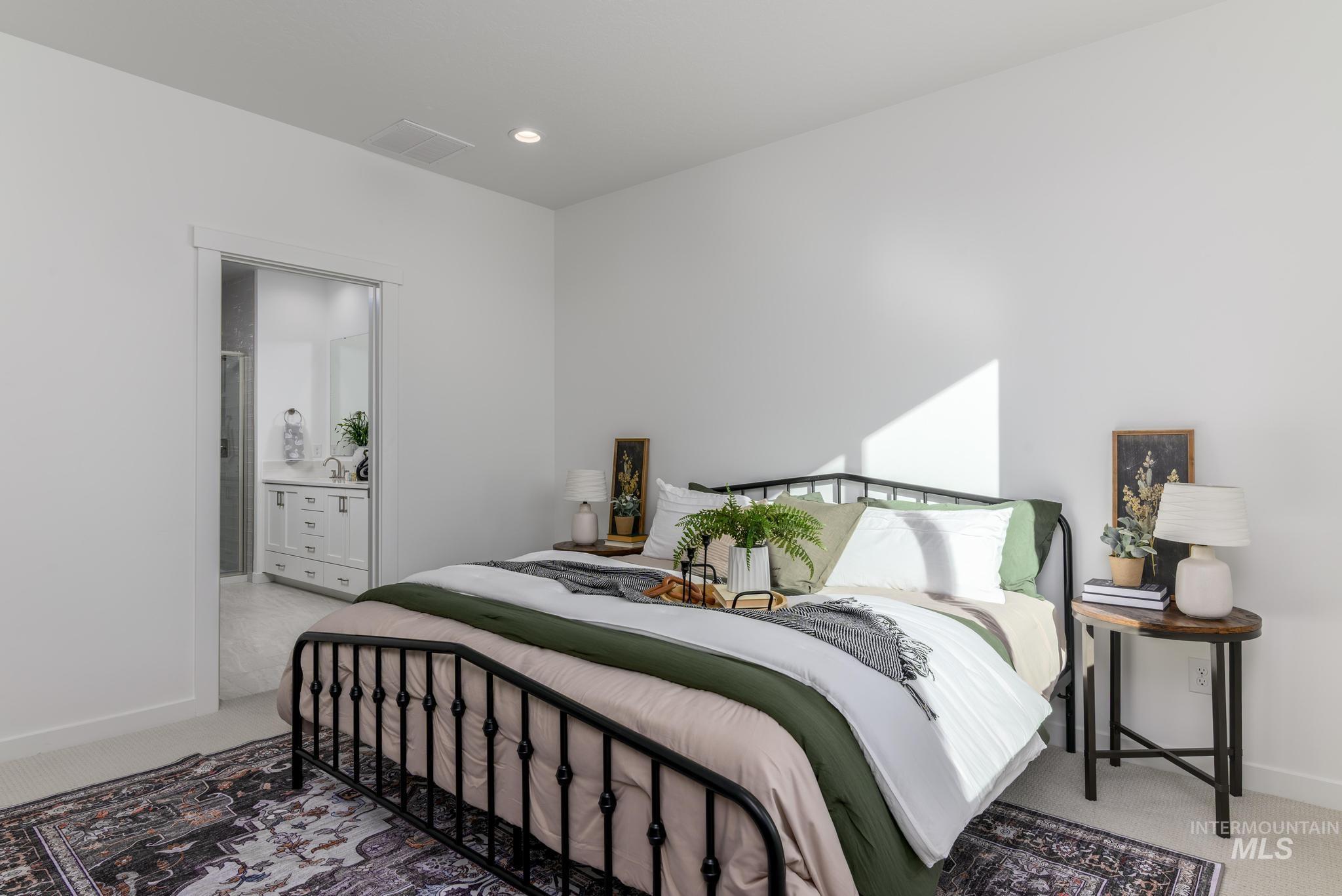 Bedroom with light carpet, recessed lighting, and ensuite bath