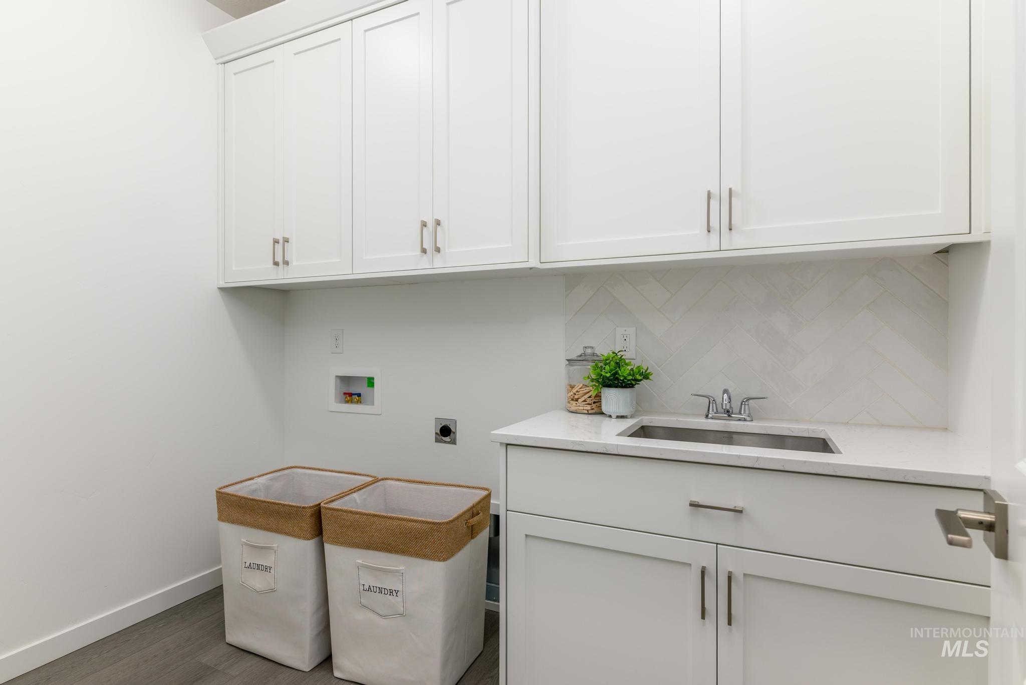 Laundry room featuring cabinet space, hookup for a washing machine, hookup for an electric dryer, and wood finished floors