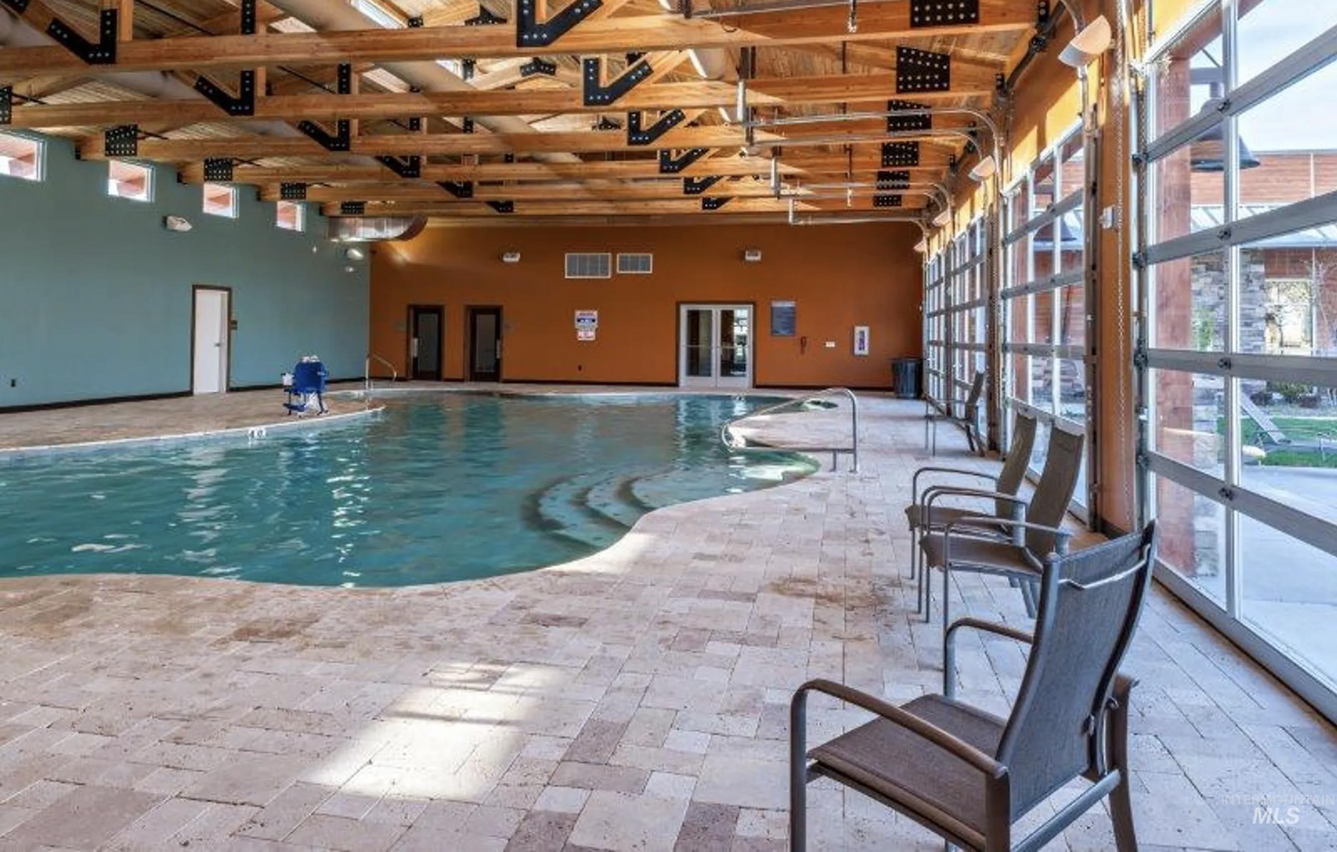 Indoor community pool featuring a patio and french doors