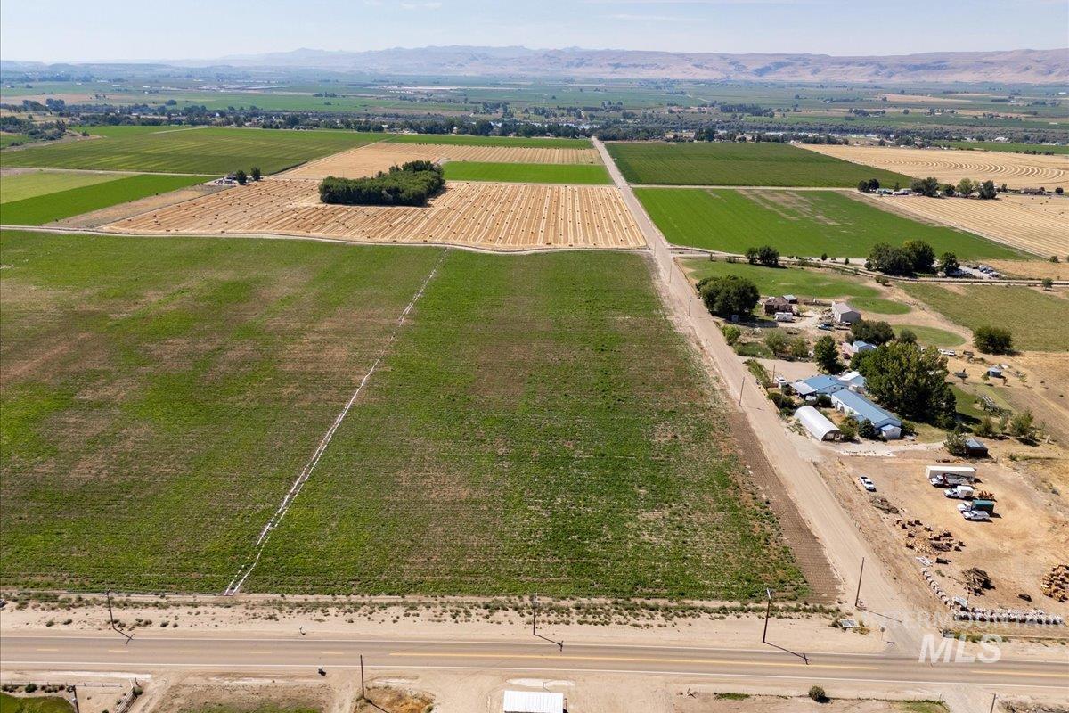 View of rural area featuring rows of crops and a mountain backdrop