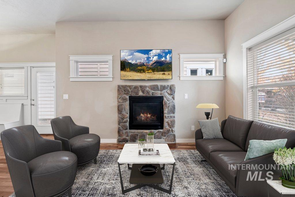 Living room featuring healthy amount of natural light, wood finished floors, and a fireplace