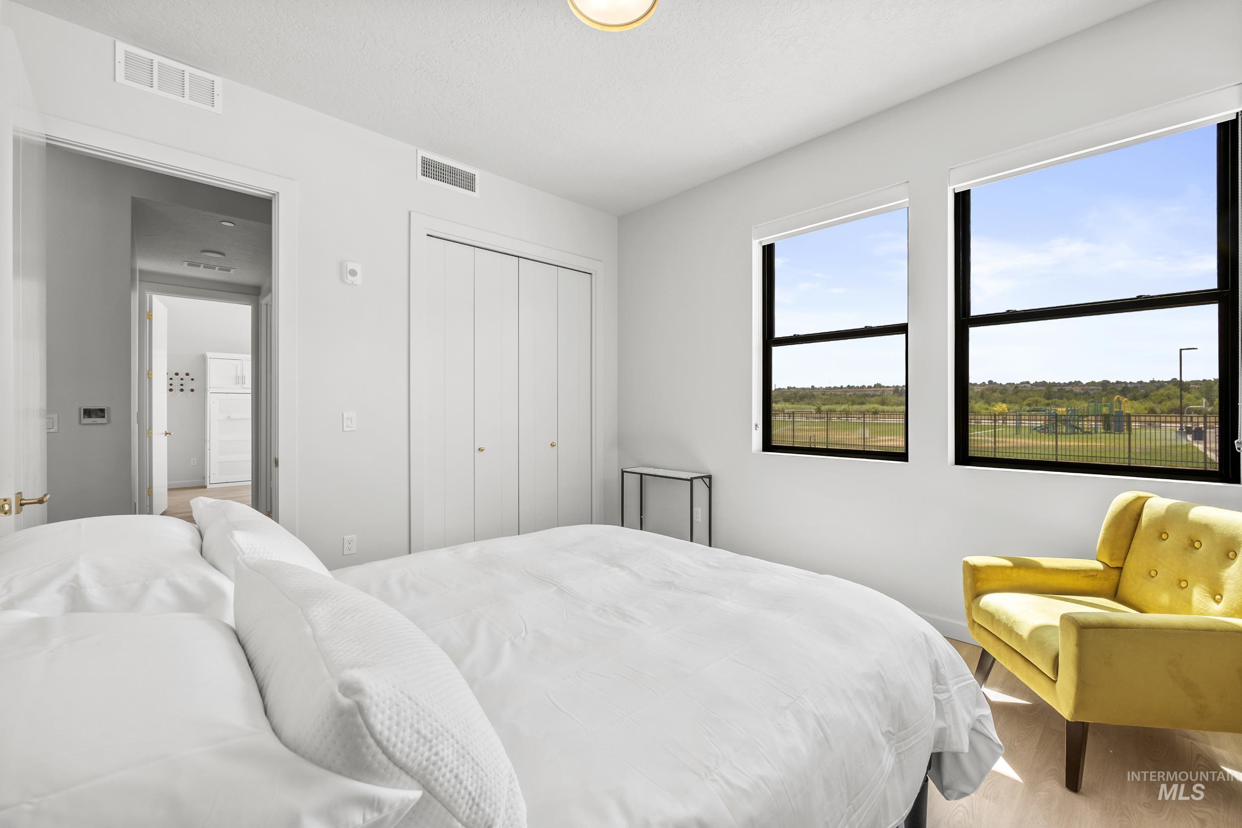 Bedroom featuring wood finished floors, a closet, and a textured ceiling
