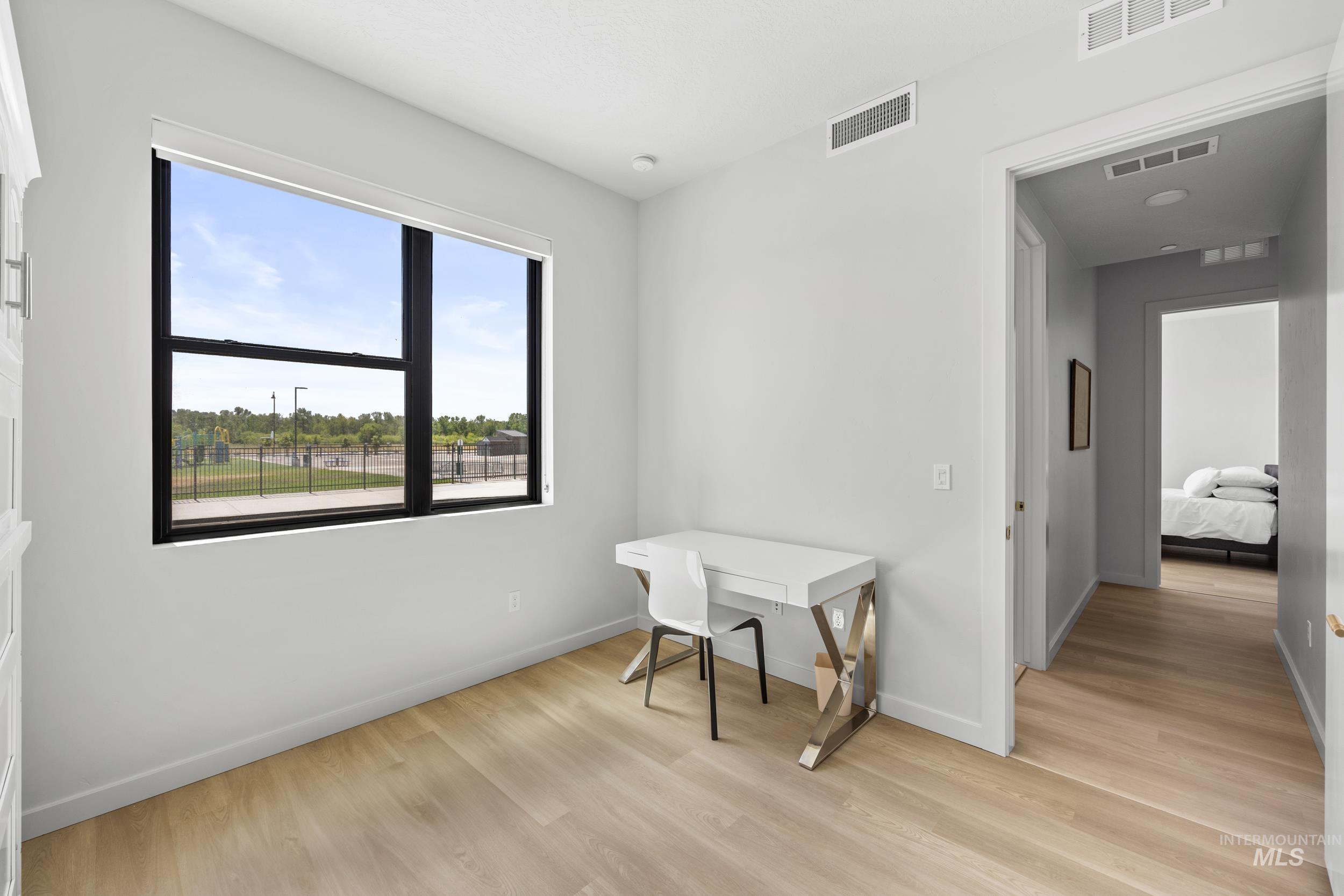 Office area featuring light wood-style flooring and baseboards