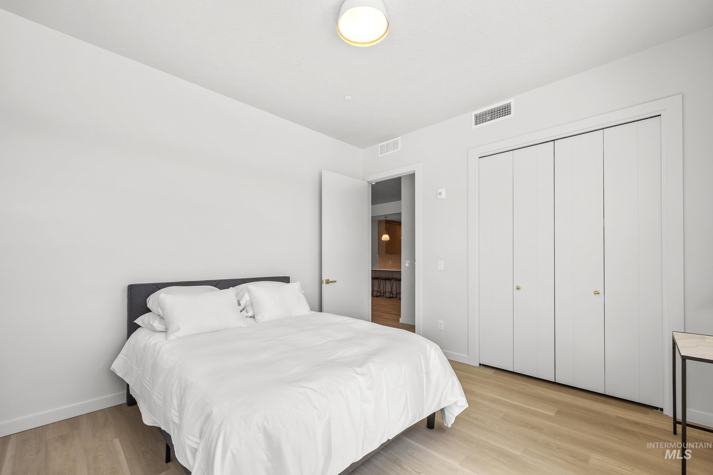 Bedroom with light wood-style floors and a closet