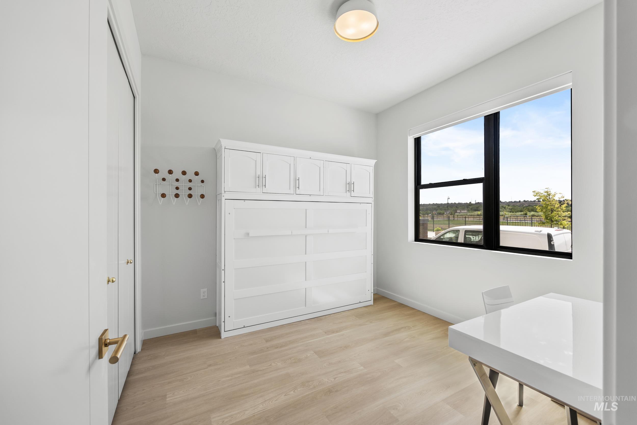 Bedroom with light wood-type flooring and baseboards