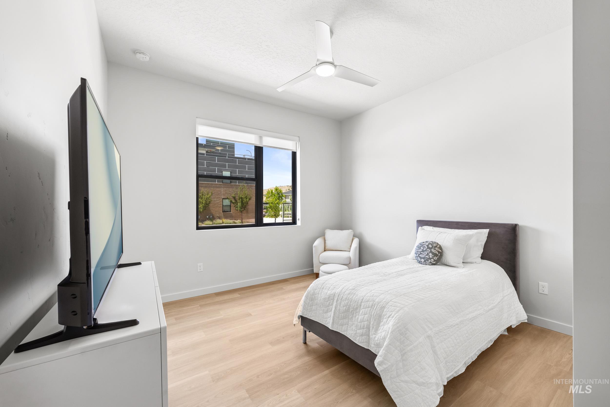 Bedroom with light wood-type flooring and a ceiling fan