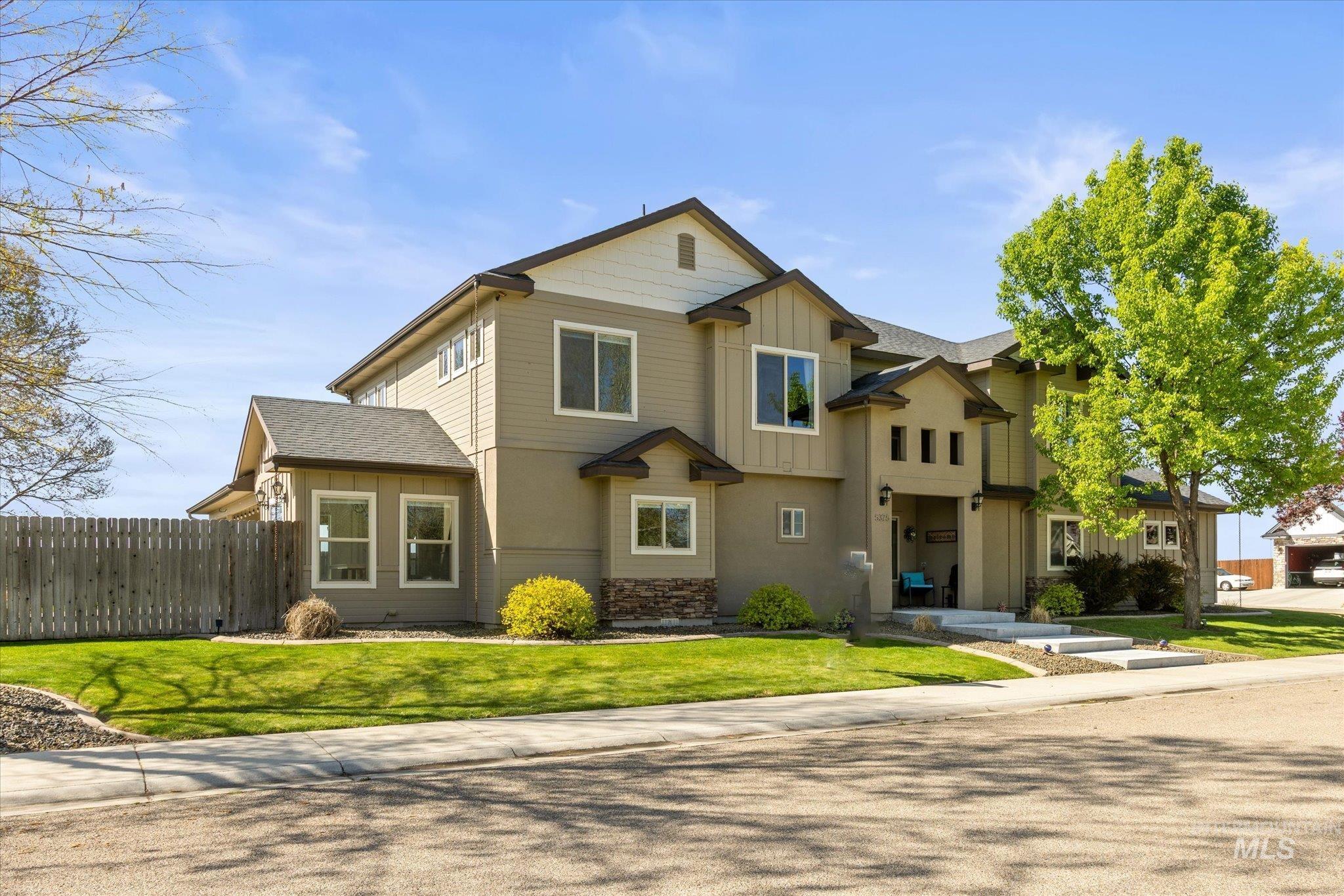 Modern residential exterior featuring a prominent two-story design with varied siding textures