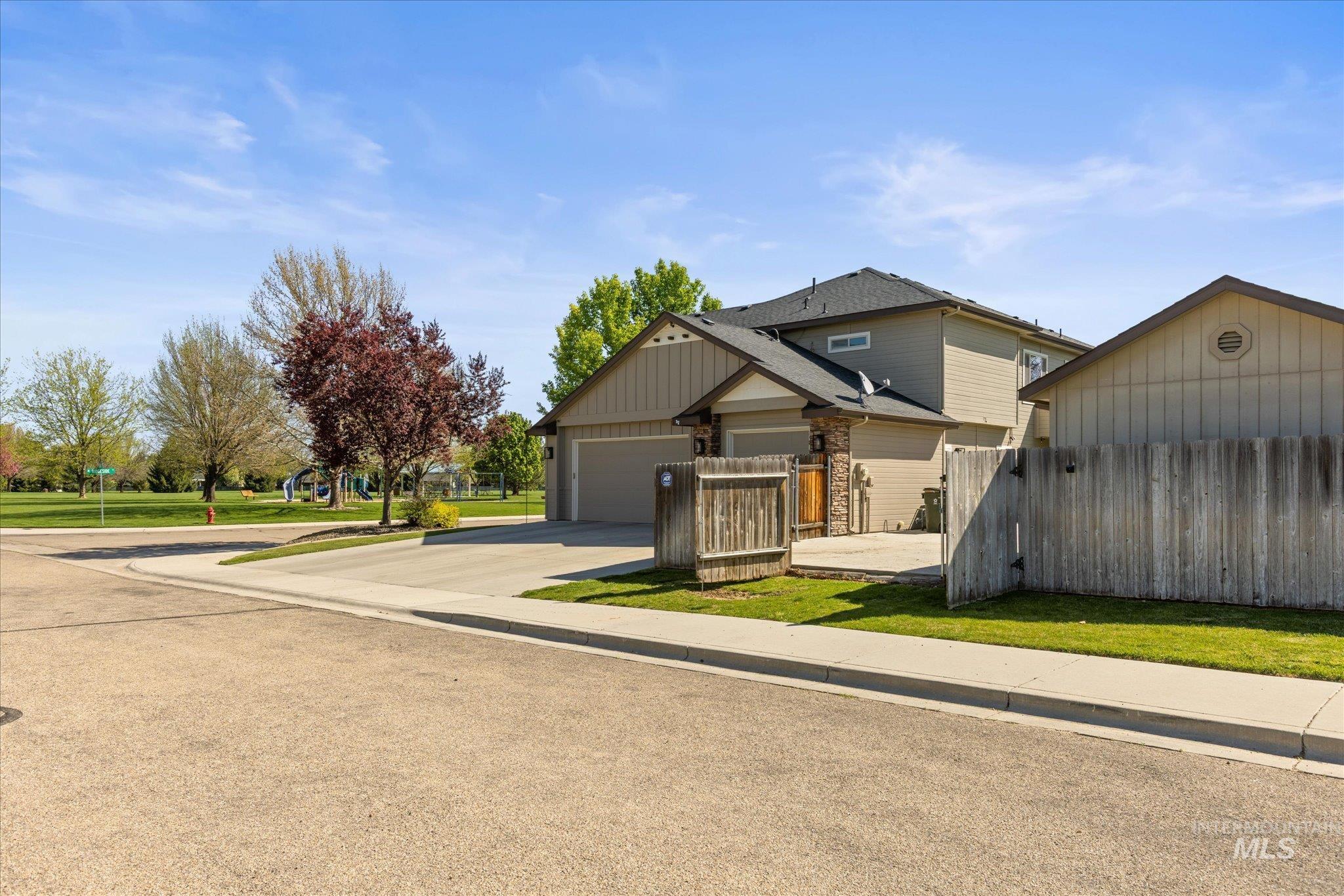 Two-story residence featuring light-colored siding, a dark shingle roof, and an integrated garage