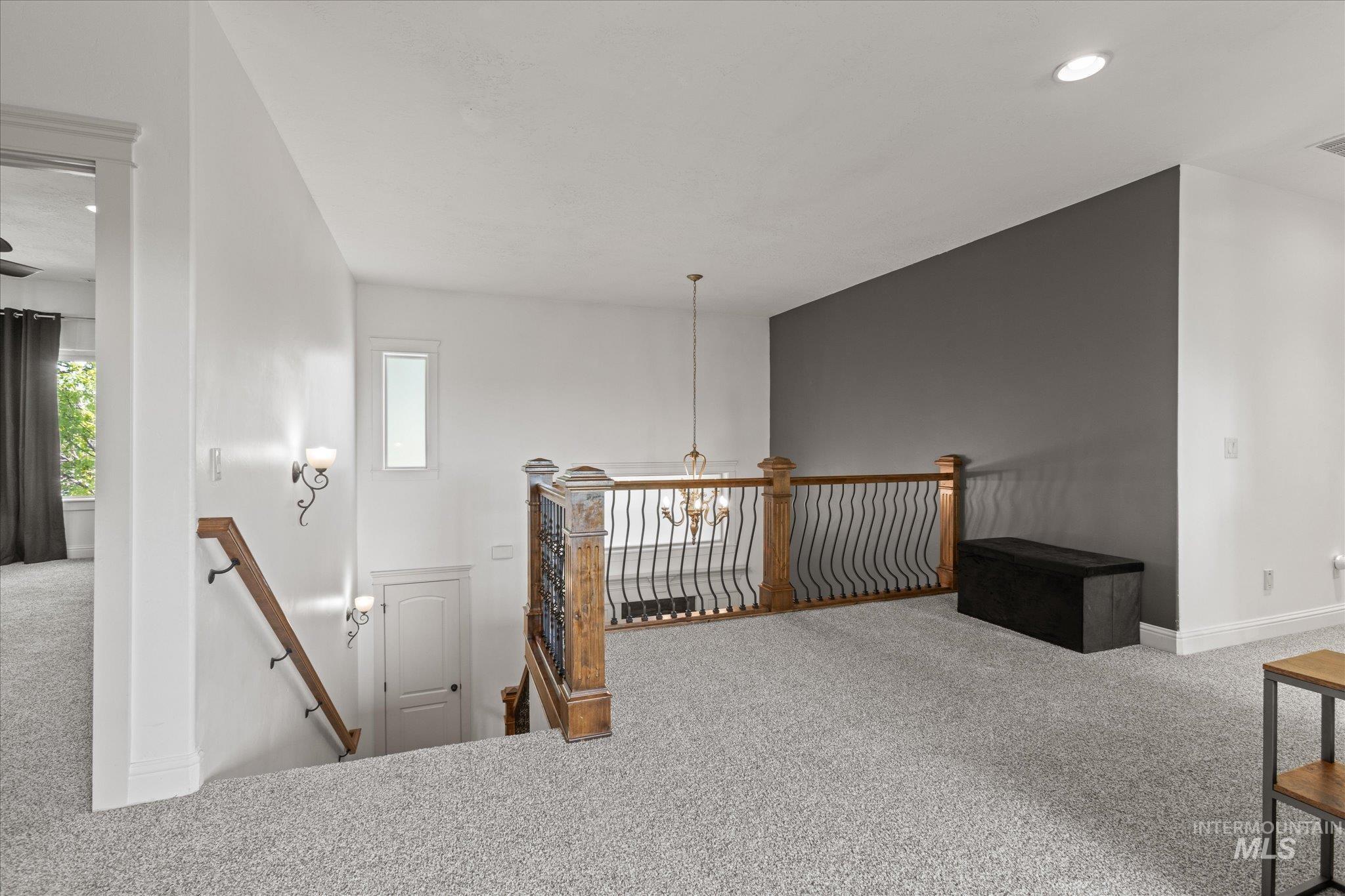 Upper-level loft with recessed lighting and light gray carpeting