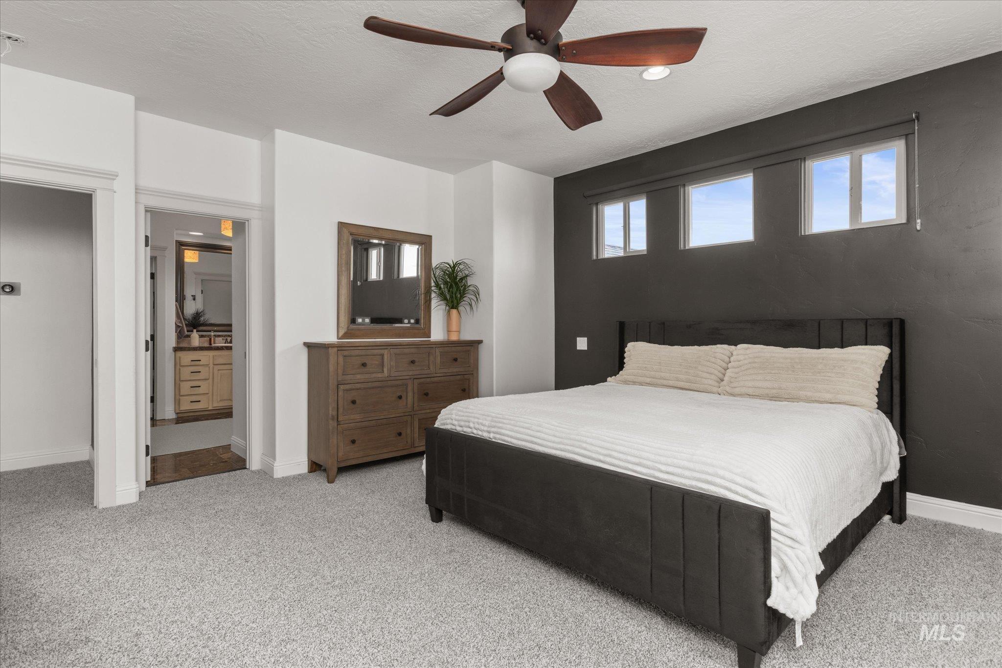 Spacious room featuring light-colored carpeting and a dark accent wall