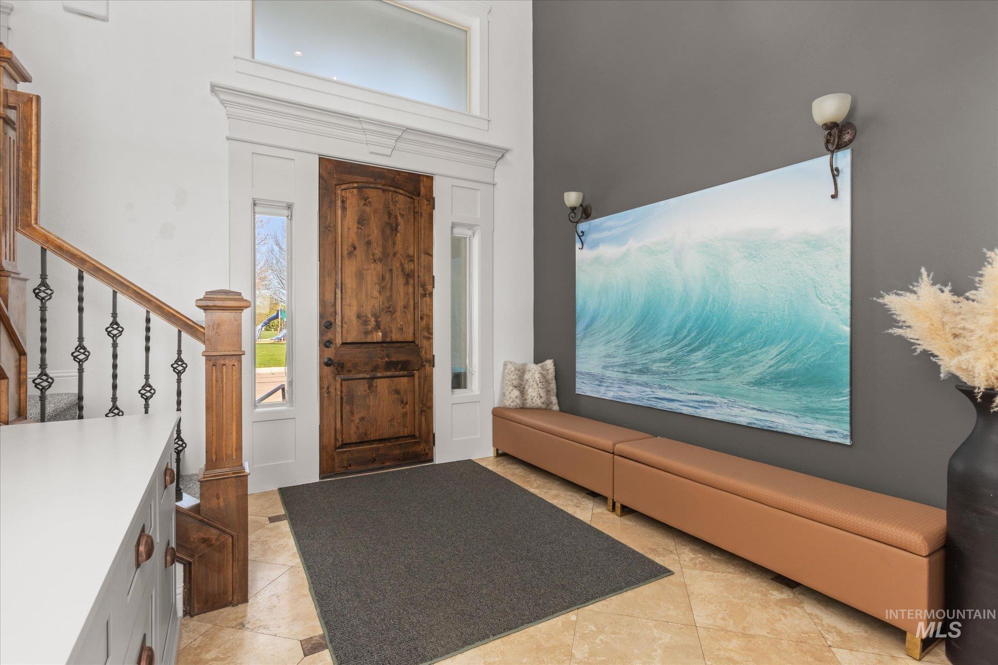 Entryway featuring a wood-panel door with decorative trim, sidelight windows, and an upper transom window