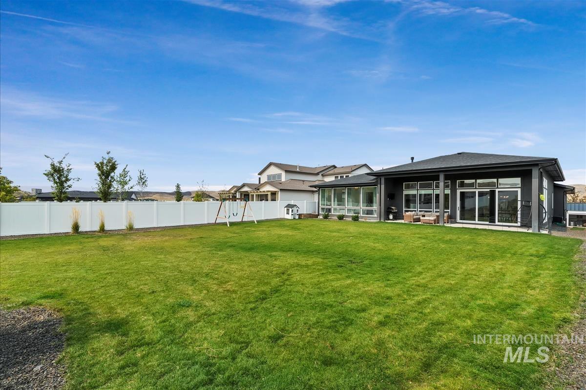 Back of property featuring a fenced backyard and a sunroom
