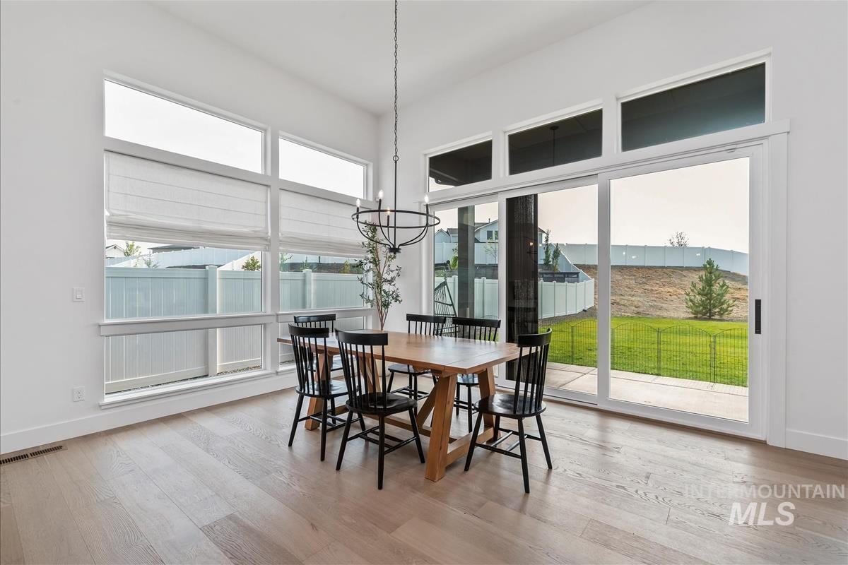 Dining room with light wood-style flooring and a chandelier