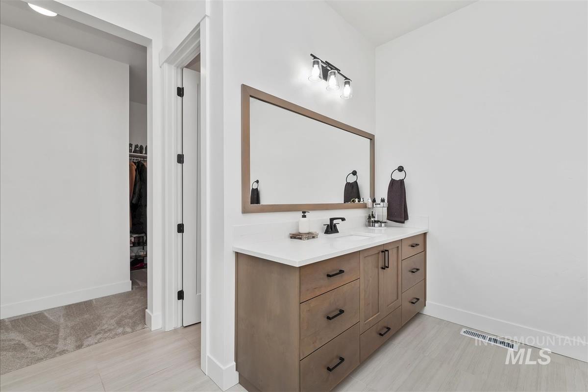 Bathroom with vanity and a spacious closet