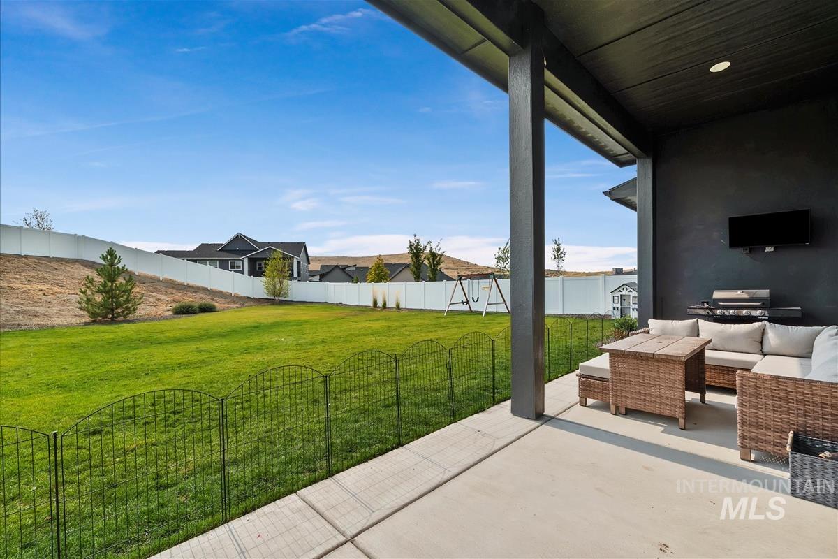 Fenced backyard with a patio, outdoor lounge area, and a grill