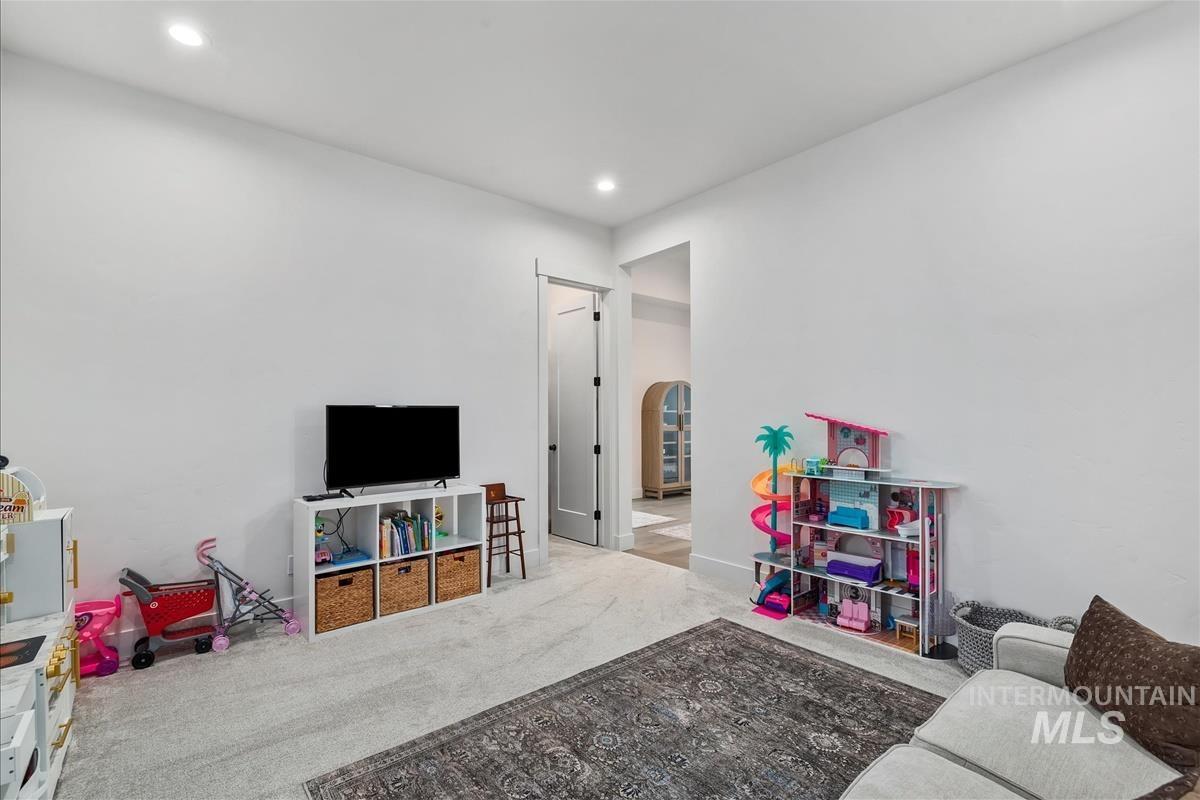 Game room featuring carpet floors, arched walkways, and recessed lighting