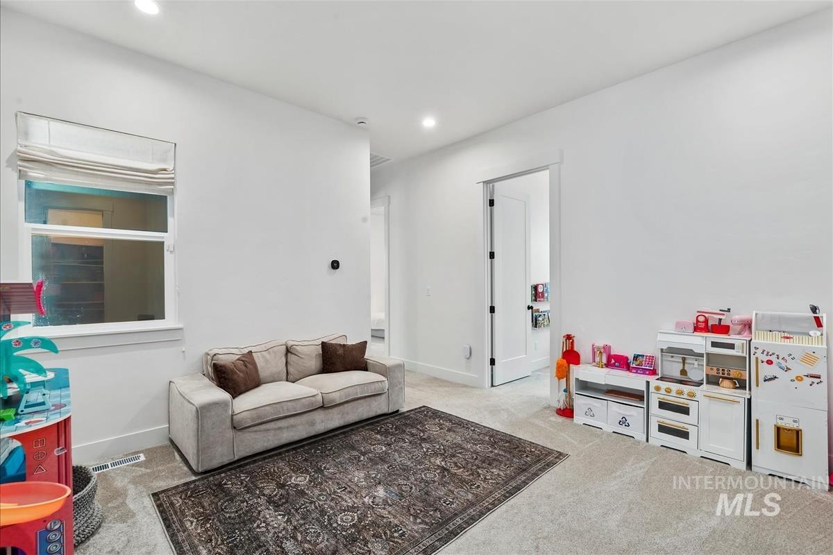 Living area with light colored carpet and recessed lighting