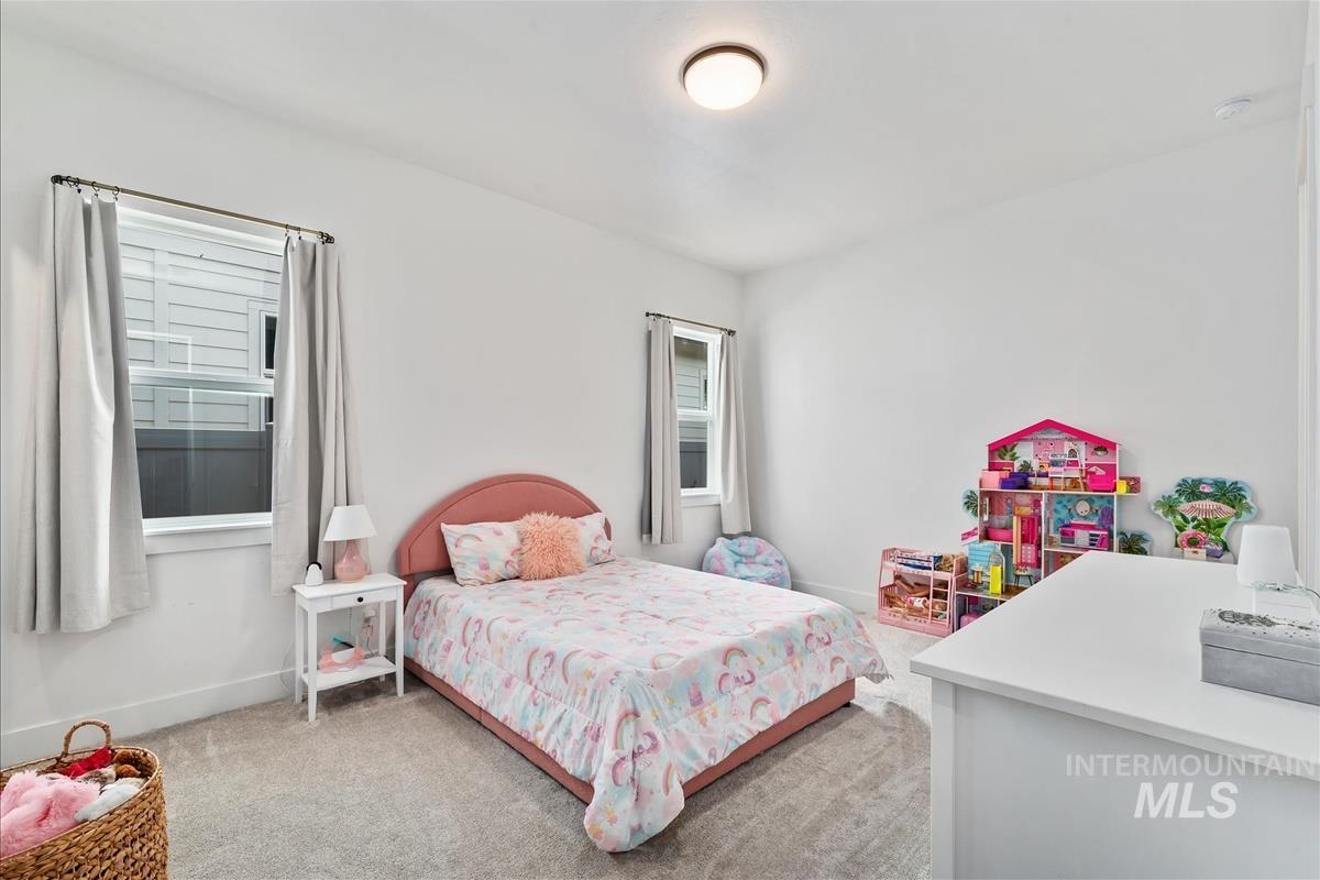 Bedroom with baseboards and light carpet