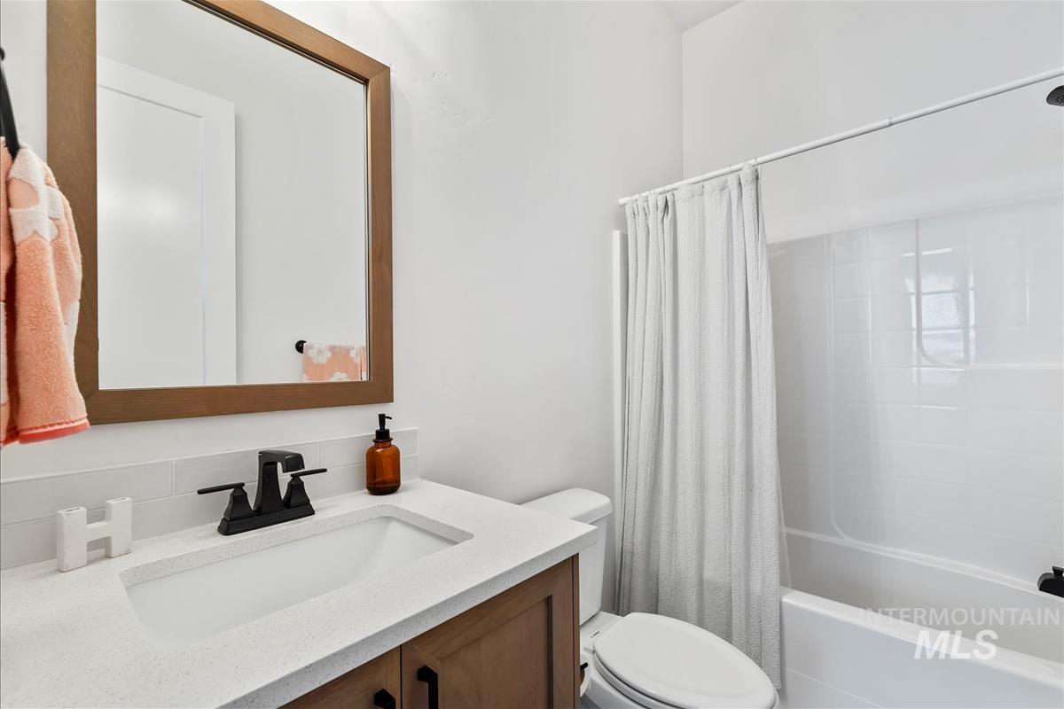 Bathroom with shower / bath combo with shower curtain and vanity