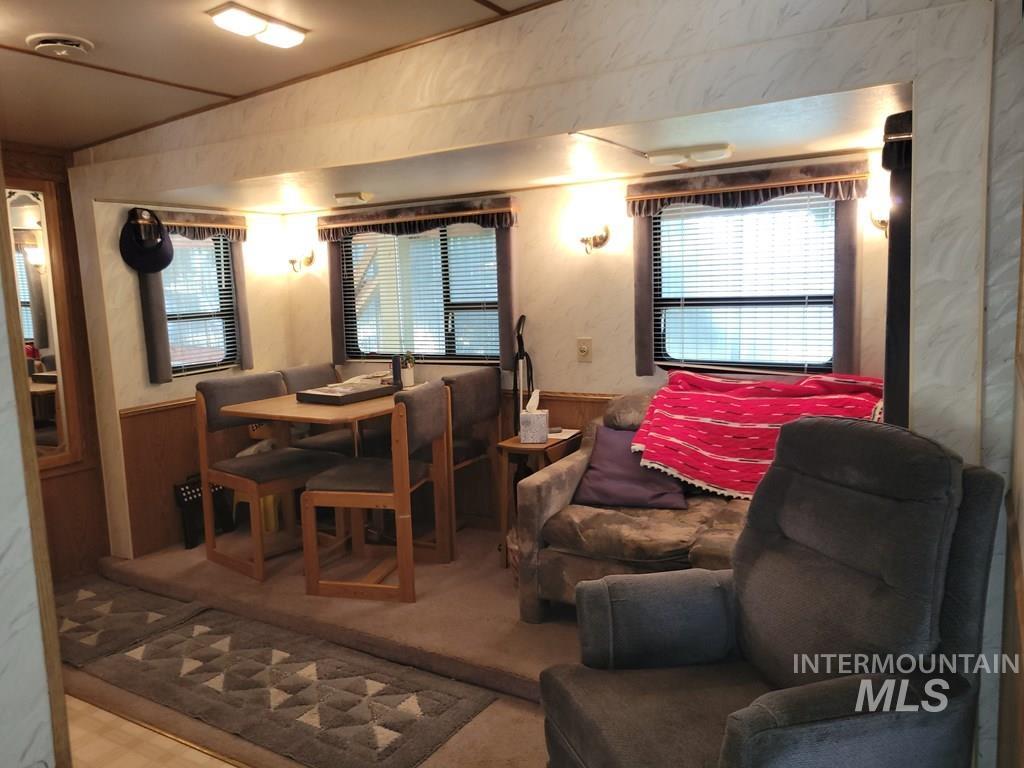 Dining area with wainscoting, wood walls, and tile patterned floors