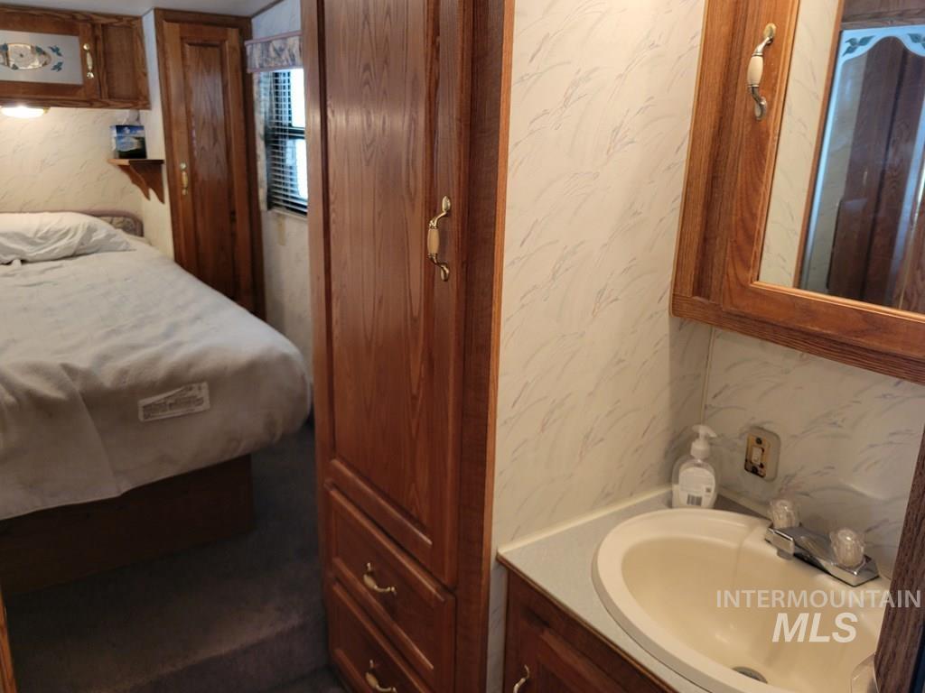Bedroom featuring wallpapered walls and a sink