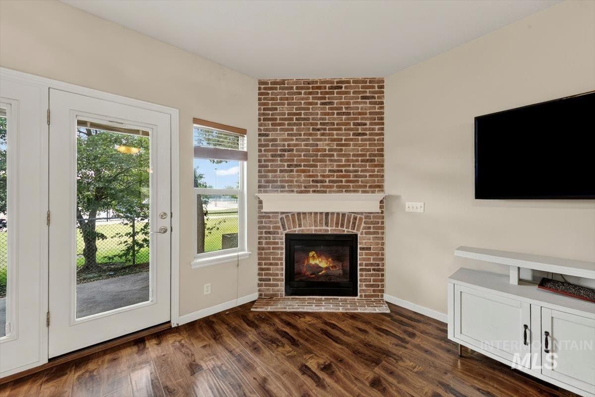 Corner brick fireplace with a white mantel and hearth