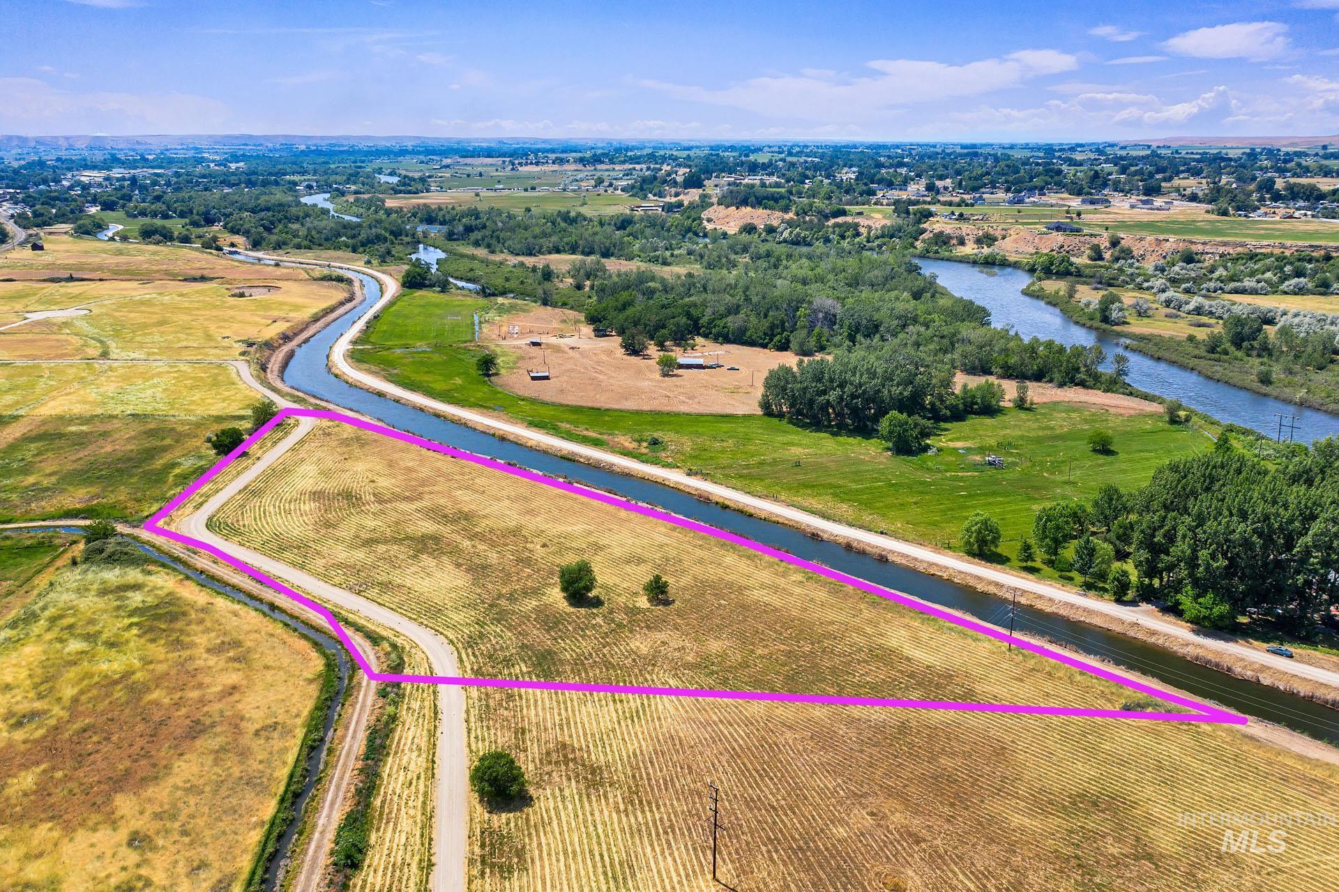 Aerial view of property and surrounding area featuring a nearby body of water and property boundaries highlighted