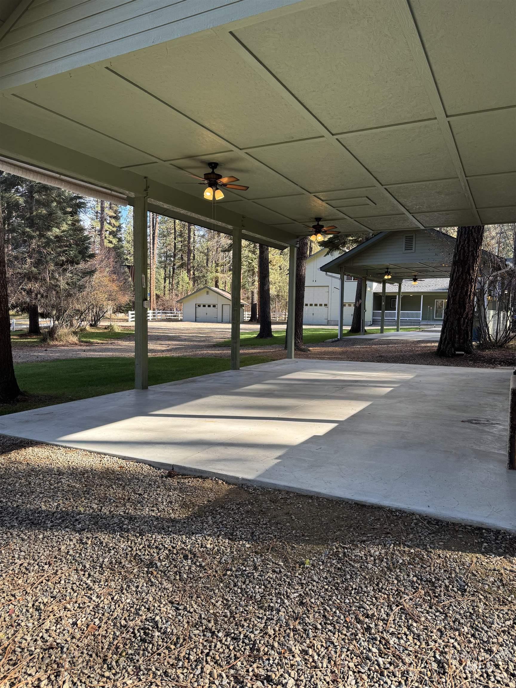 View of patio with a ceiling fan and an outbuilding